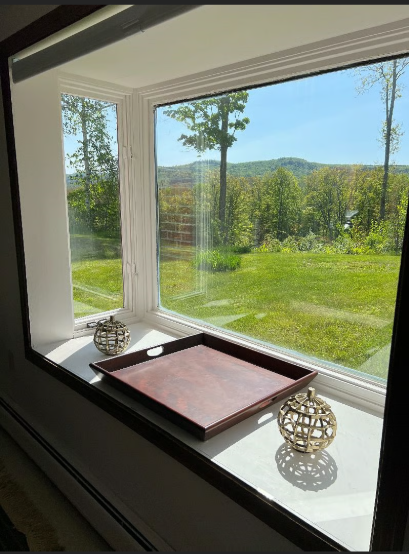 Window sill with decorative items and a view of greenery outside