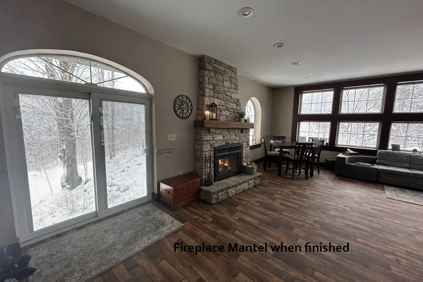Living room with fireplace and large windows showing a snowy landscape