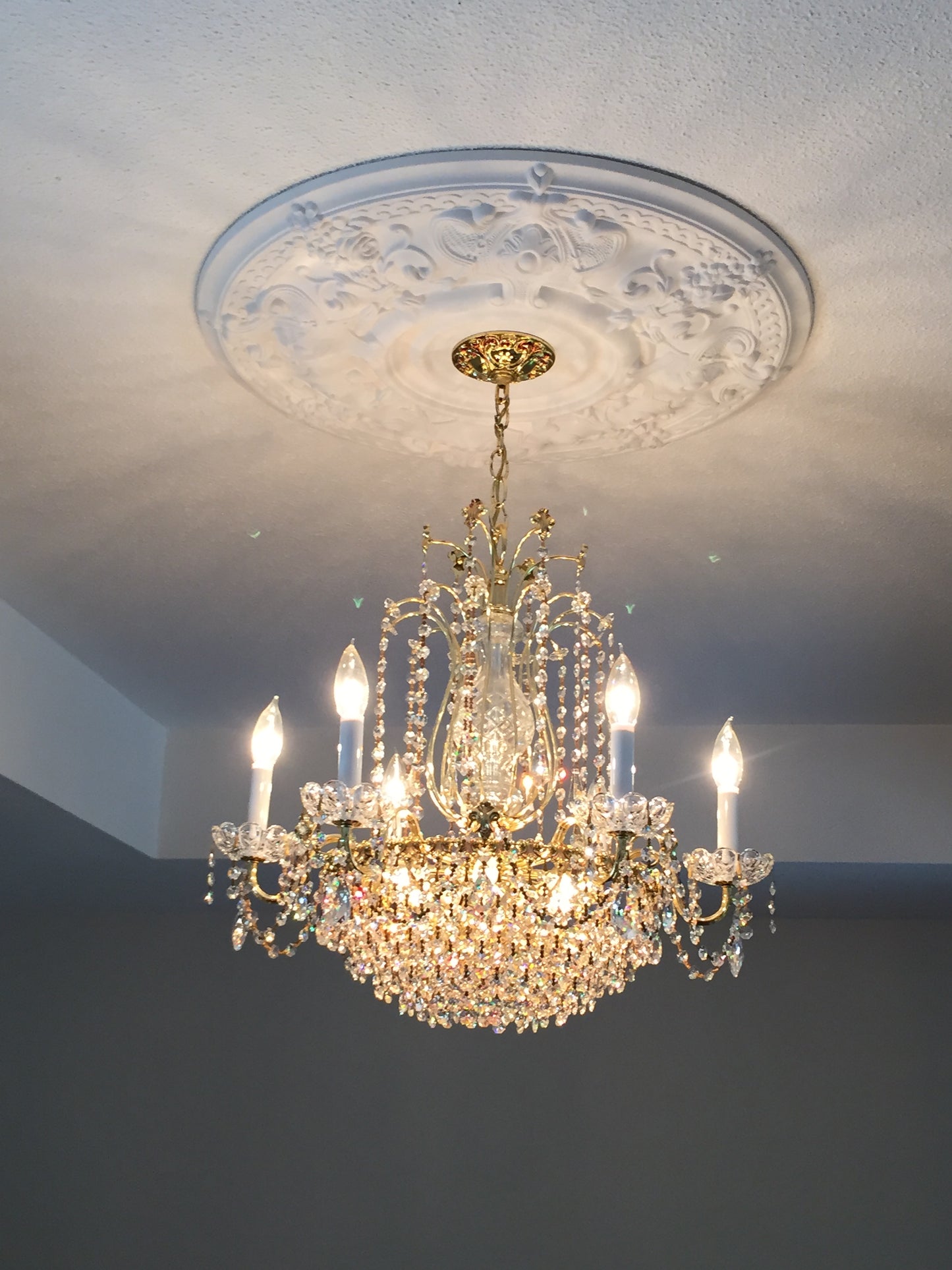 Crystal chandelier hanging against a white wall
