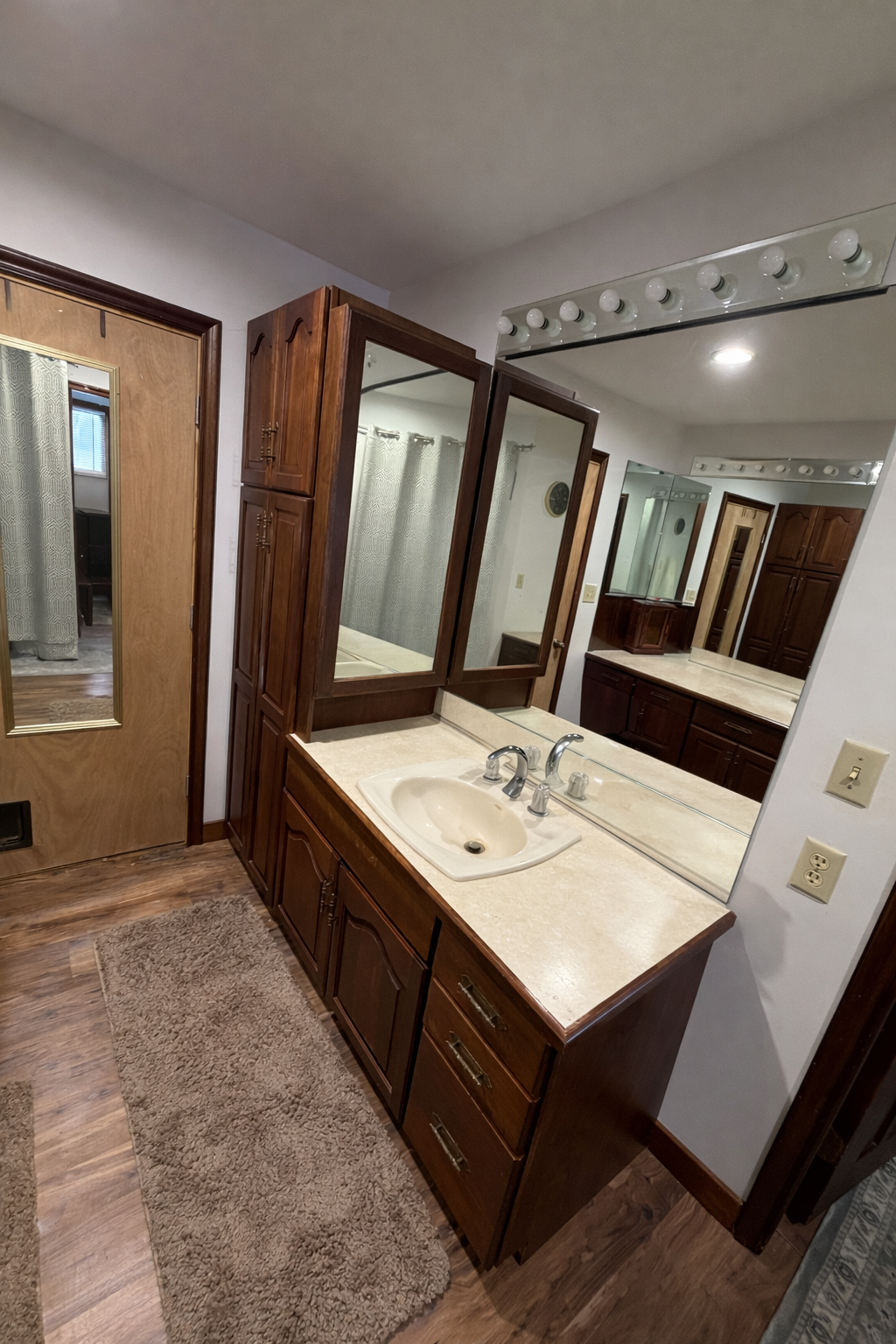 Bathroom with wooden vanity, sink, and mirrors.