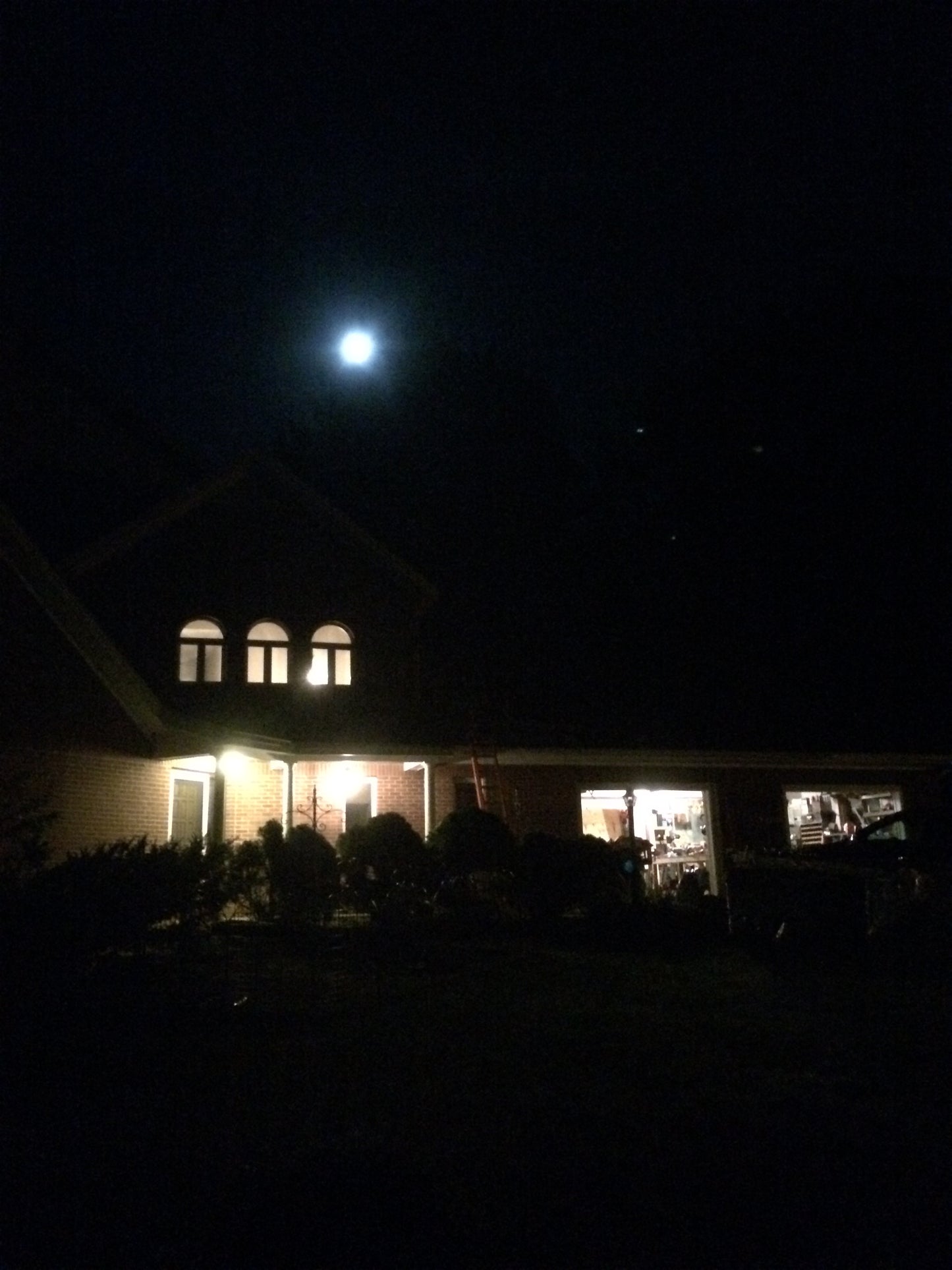 Building exterior at night with moon and with lights on