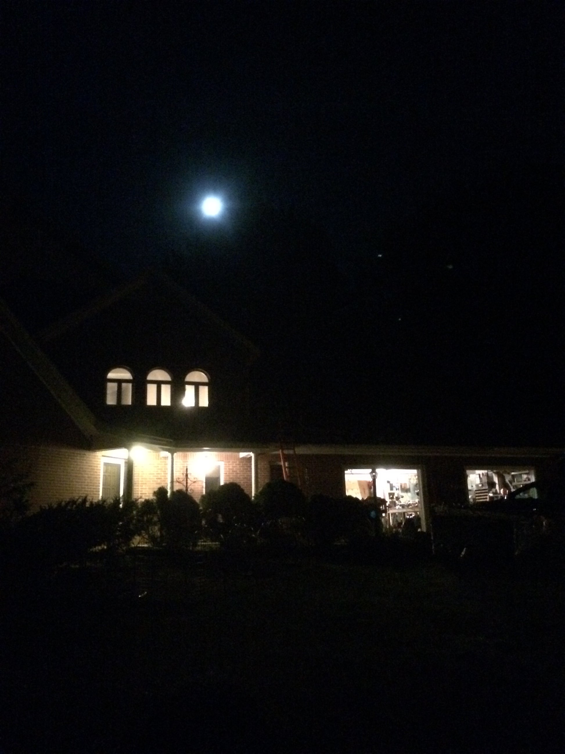 Building exterior at night with moon and with lights on