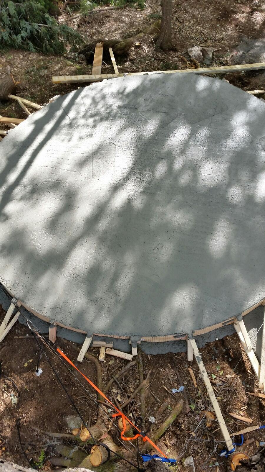Firepit base  in a forest setting with trees casting shadows on the surface
