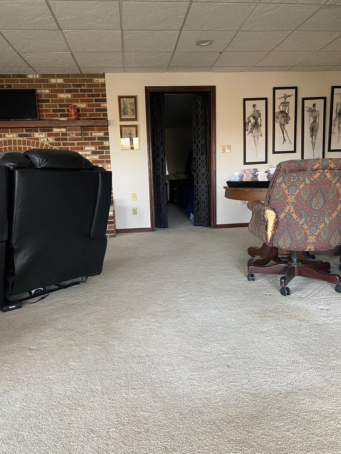 Small office or home office with a desk, chair, and framed pictures on the wall.