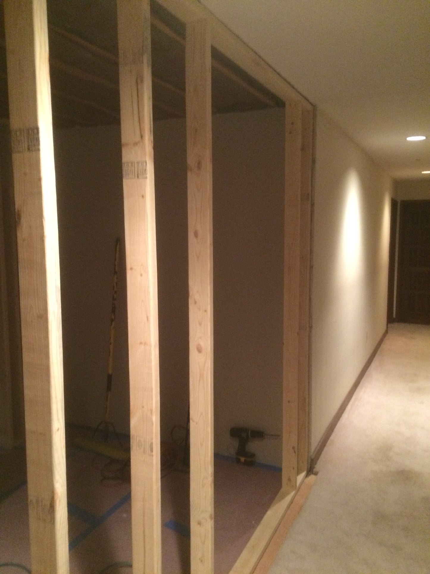Wooden frame structure inside a room with white walls and floor.