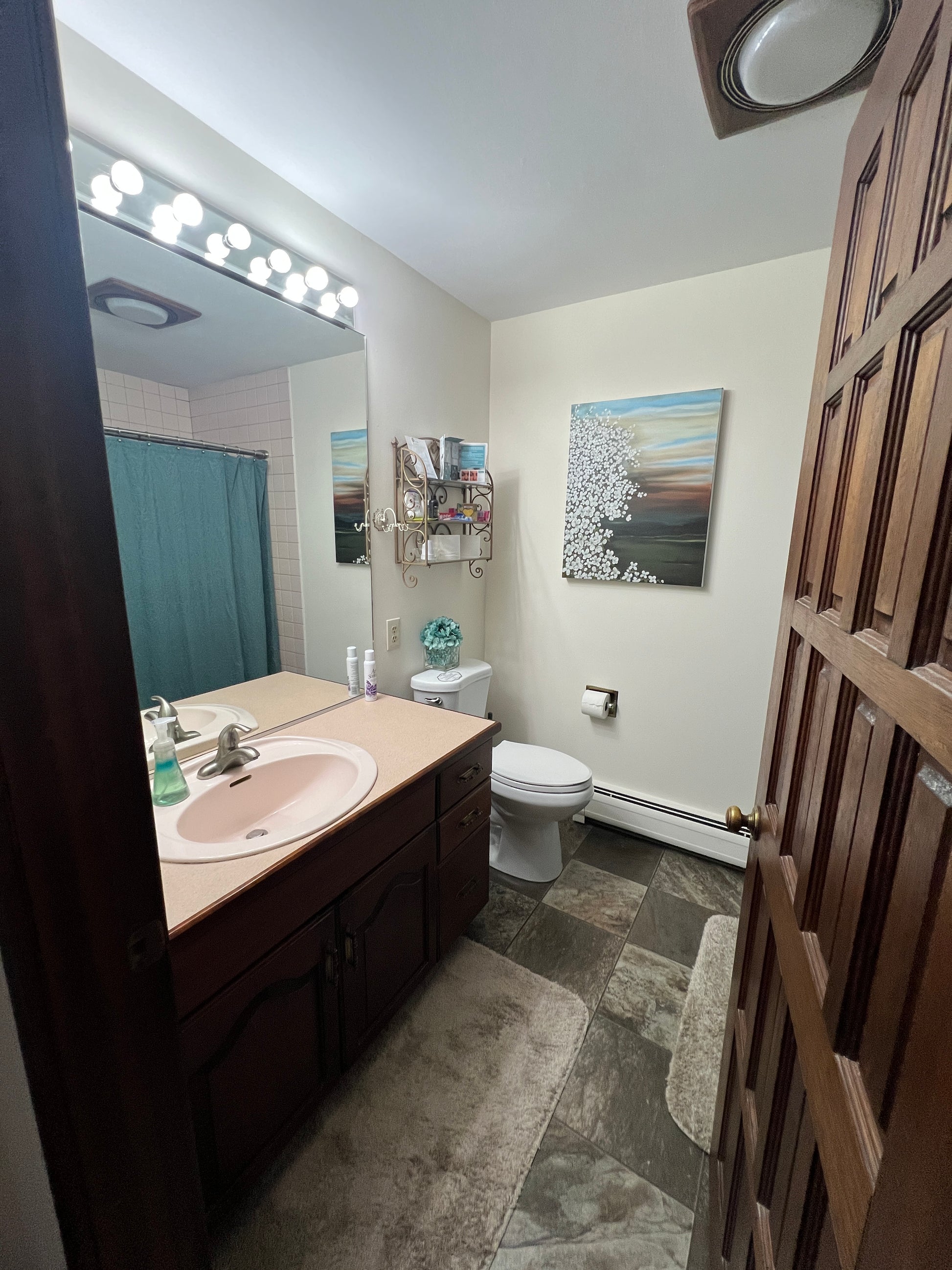 Bathroom interior with vanity, mirror, and toilet.