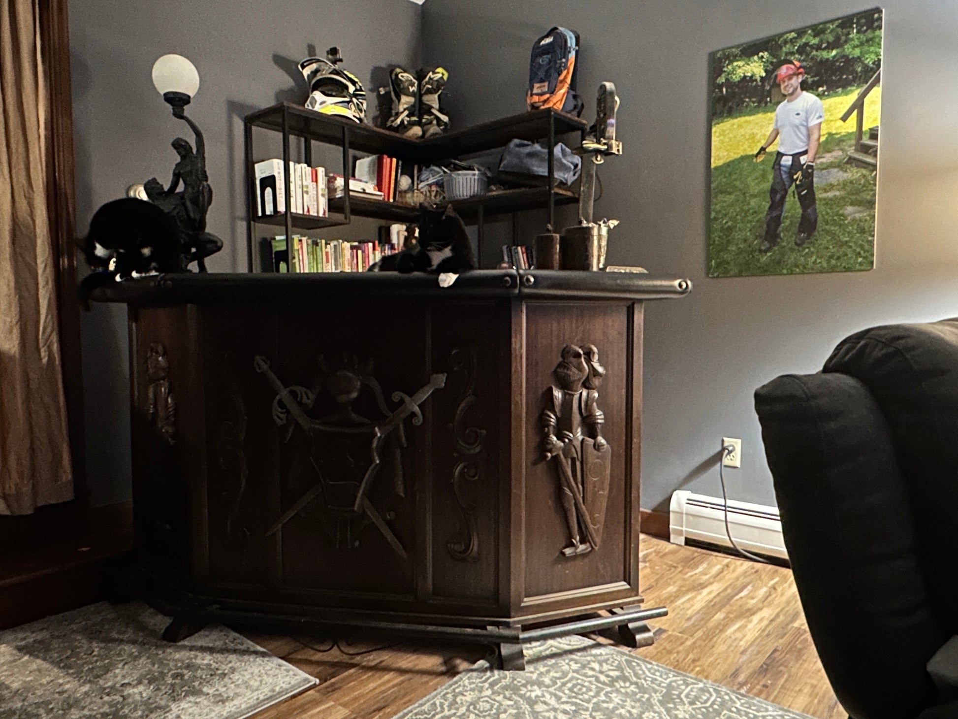 Wooden bar  cabinet with decorative carvings in a room with a couch and wall art.