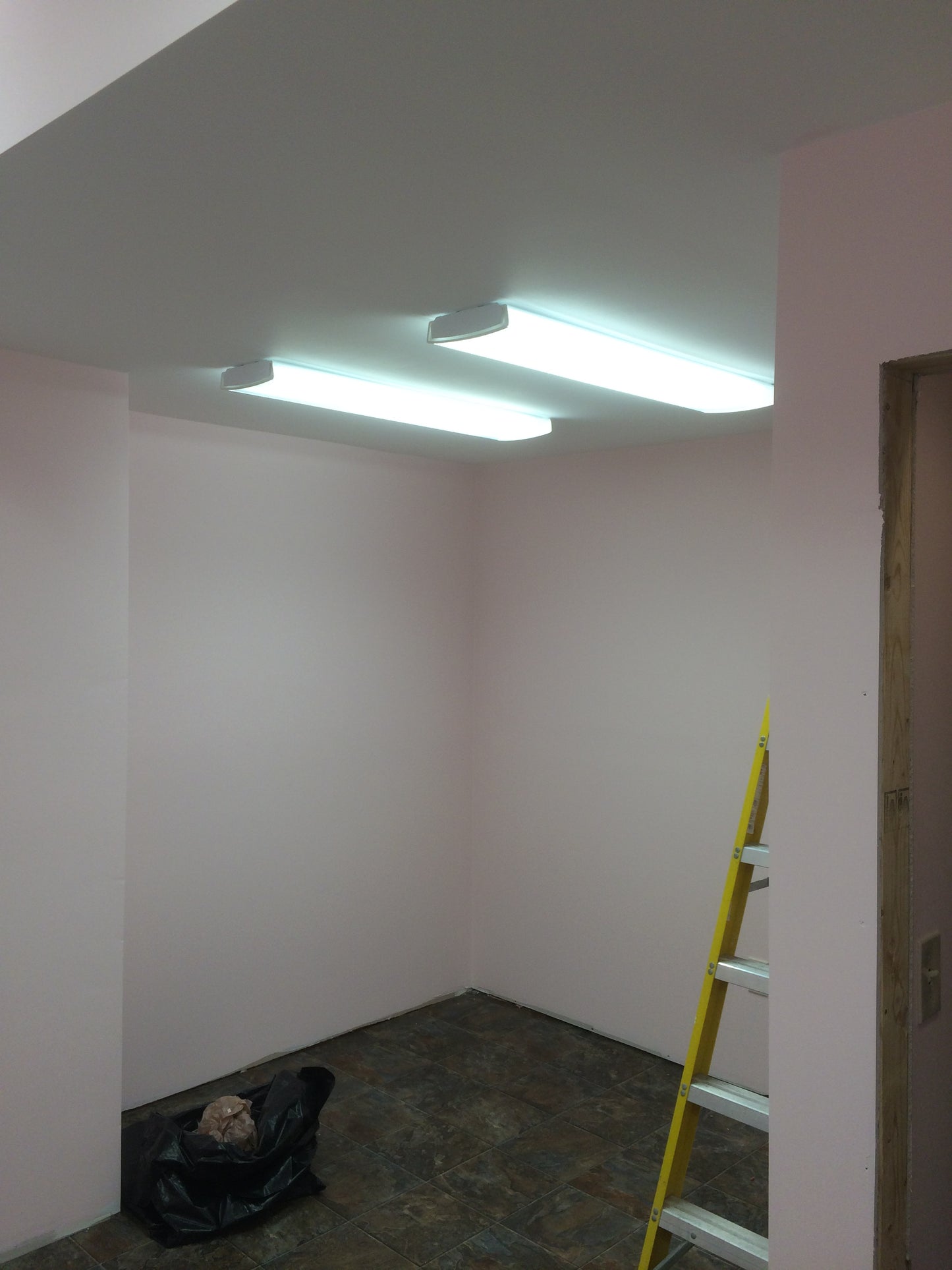 White wall with a yellow level tool on top, indicating a construction or renovation setting.