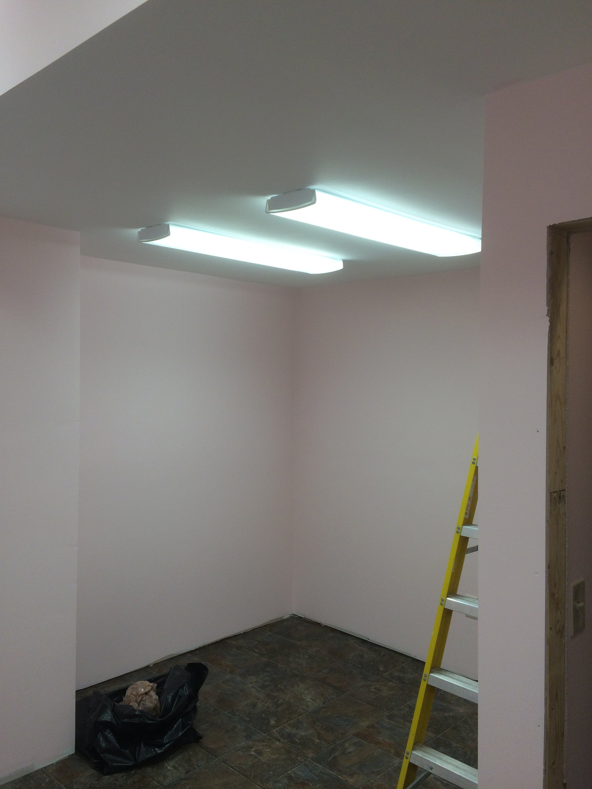 White wall with a yellow level tool on top, indicating a construction or renovation setting.