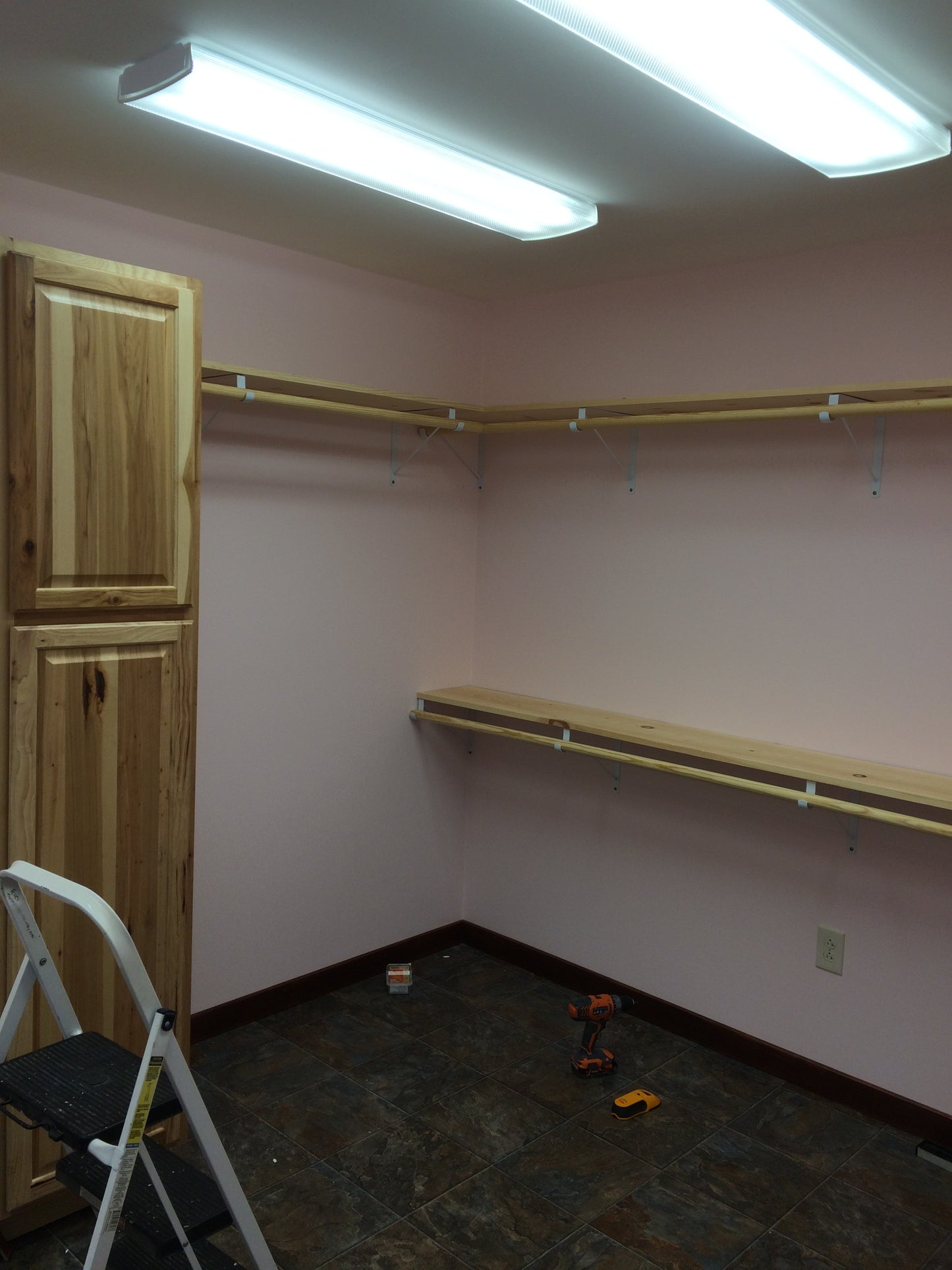 Unfinished closet room with exposed wooden beams and a window.