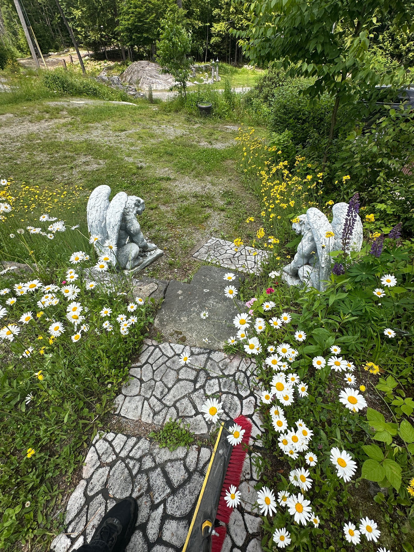 Statues and flowers in a garden setting with a stone path.