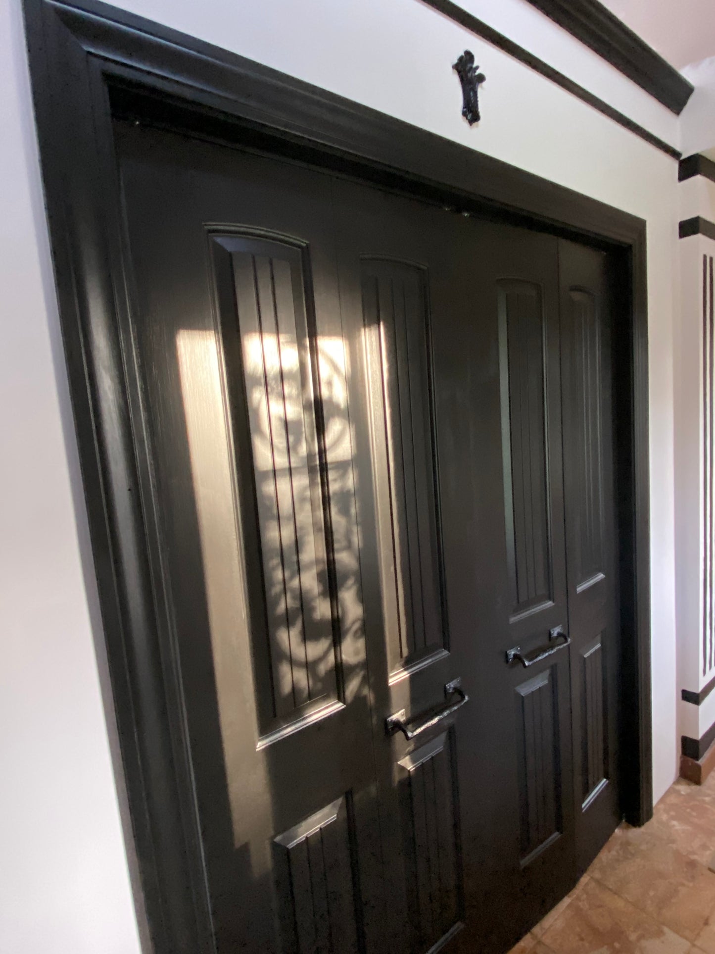 Black metal door with decorative patterns on a white background