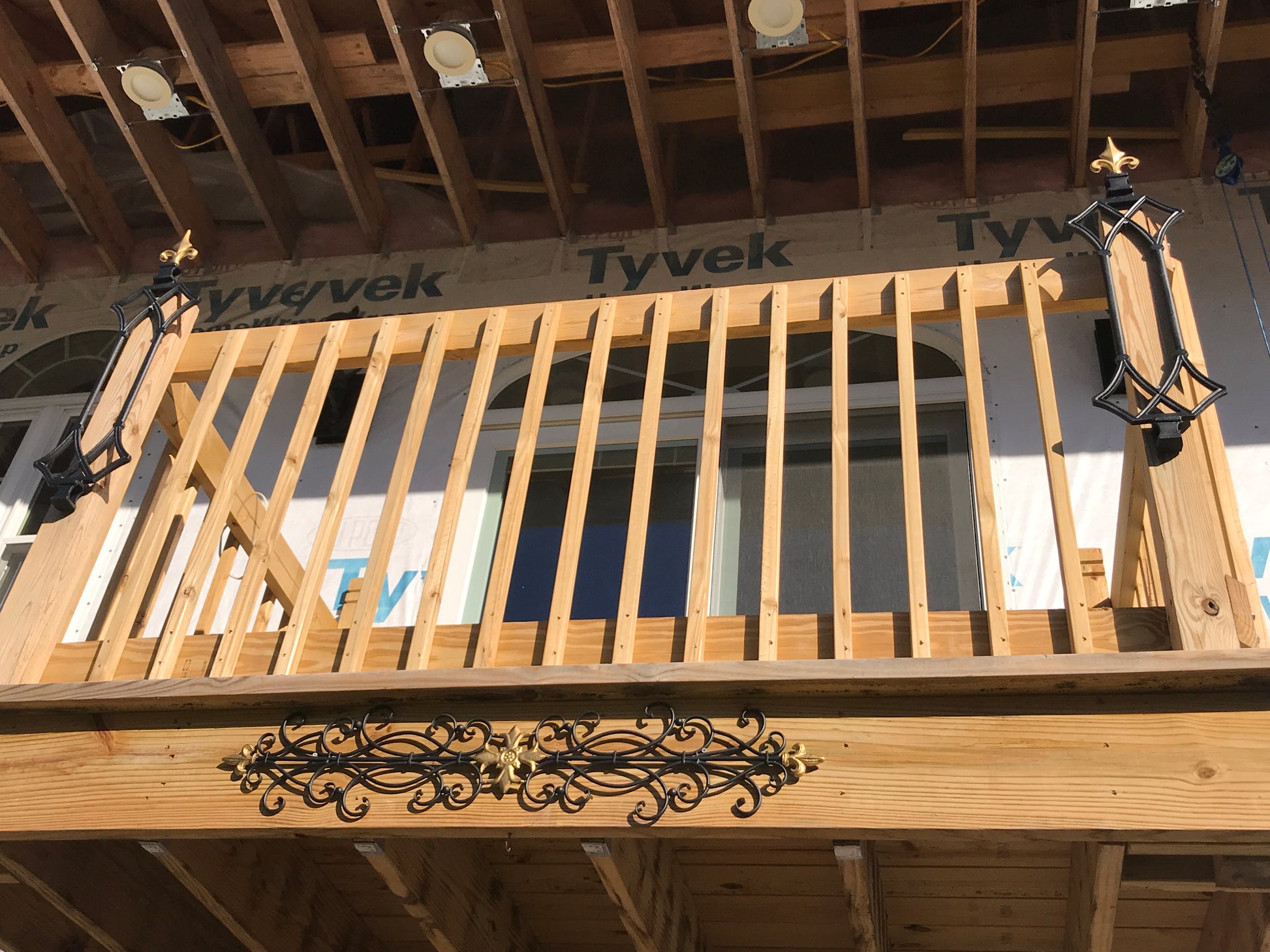 Wooden deck with decorative metal brackets on a wooden floor.