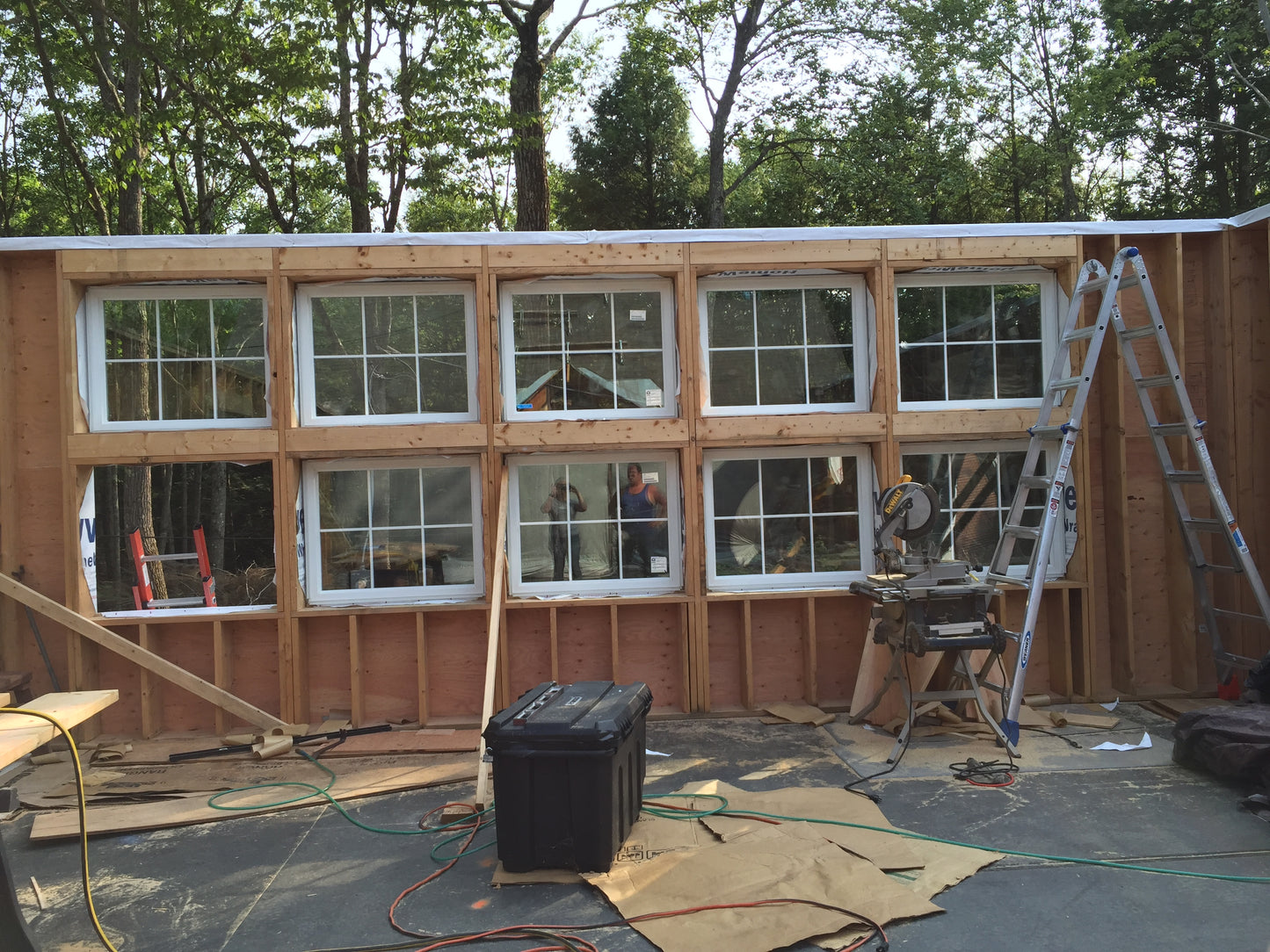Building under construction with windows and a ladder in an outdoor setting