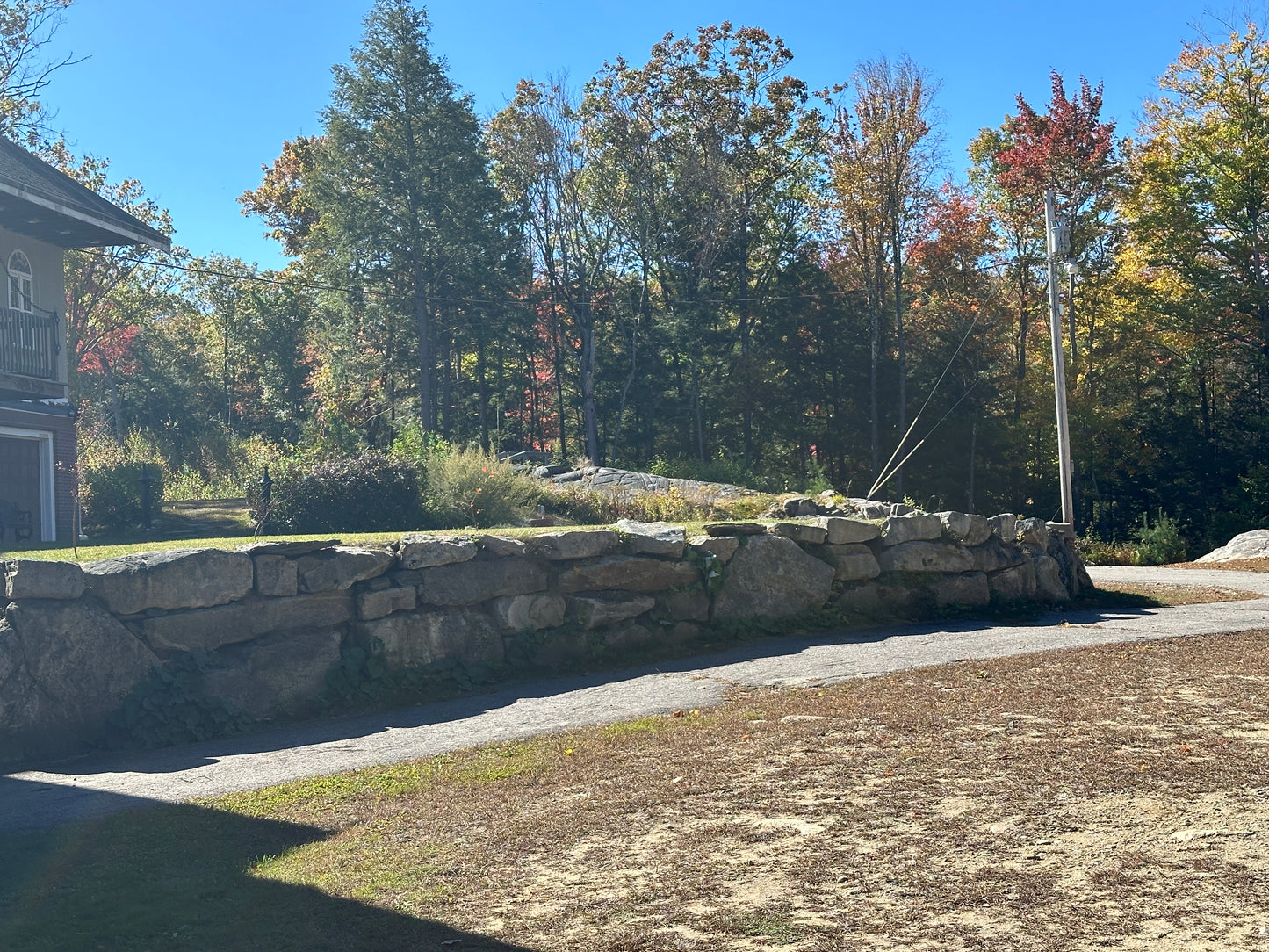 Stone retaining wall with trees and clear sky