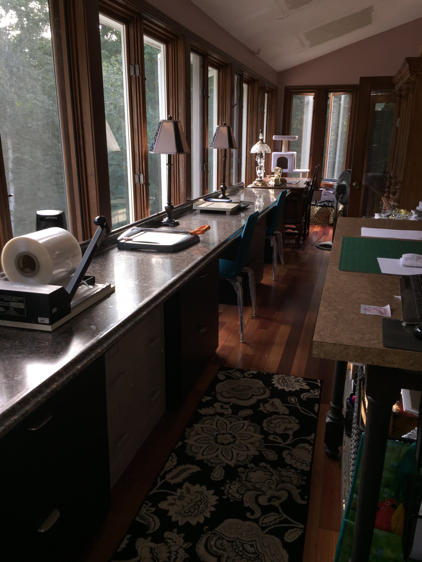 Work space area with various bottles and glasses on a counter, featuring a window view.