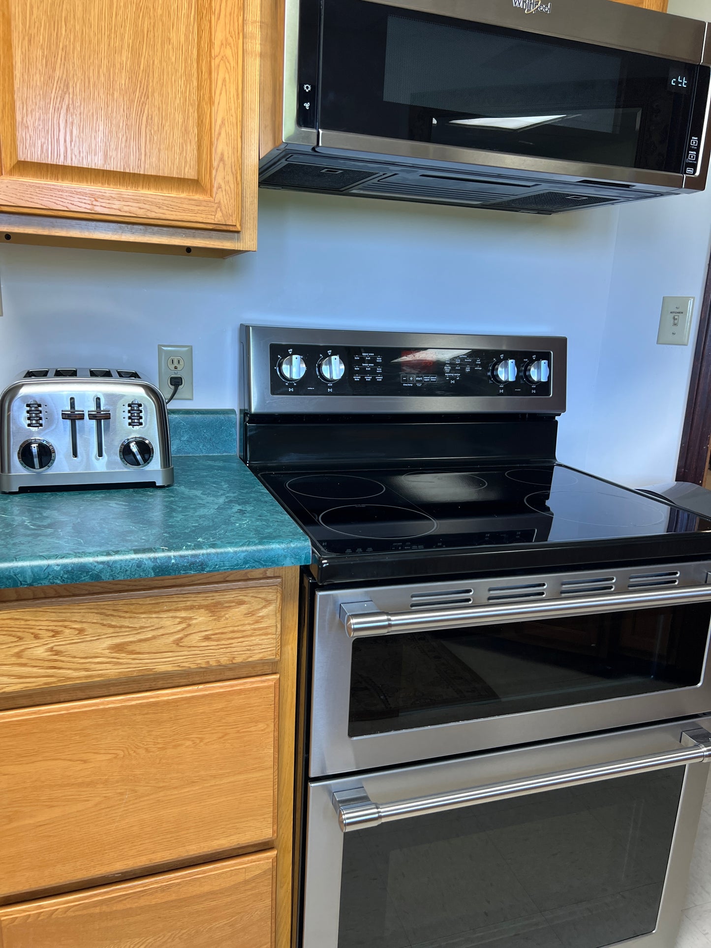 Kitchen stove with wooden cabinets and a microwave above