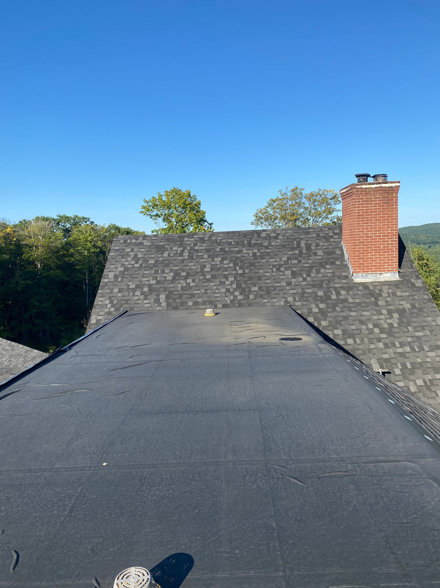 Rooftop deck with a chimney against a clear blue sky