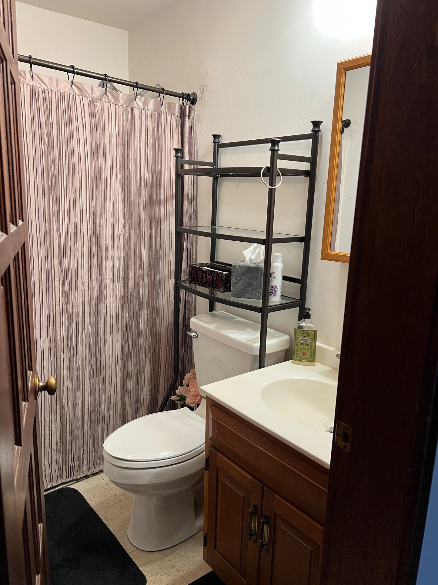 Bathroom with toilet, sink, and shower curtain.