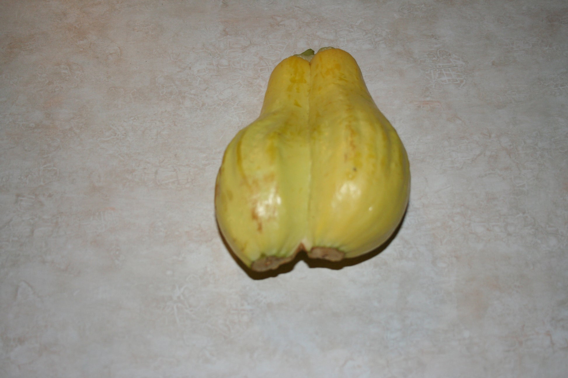 Yellow squash on a beige surface