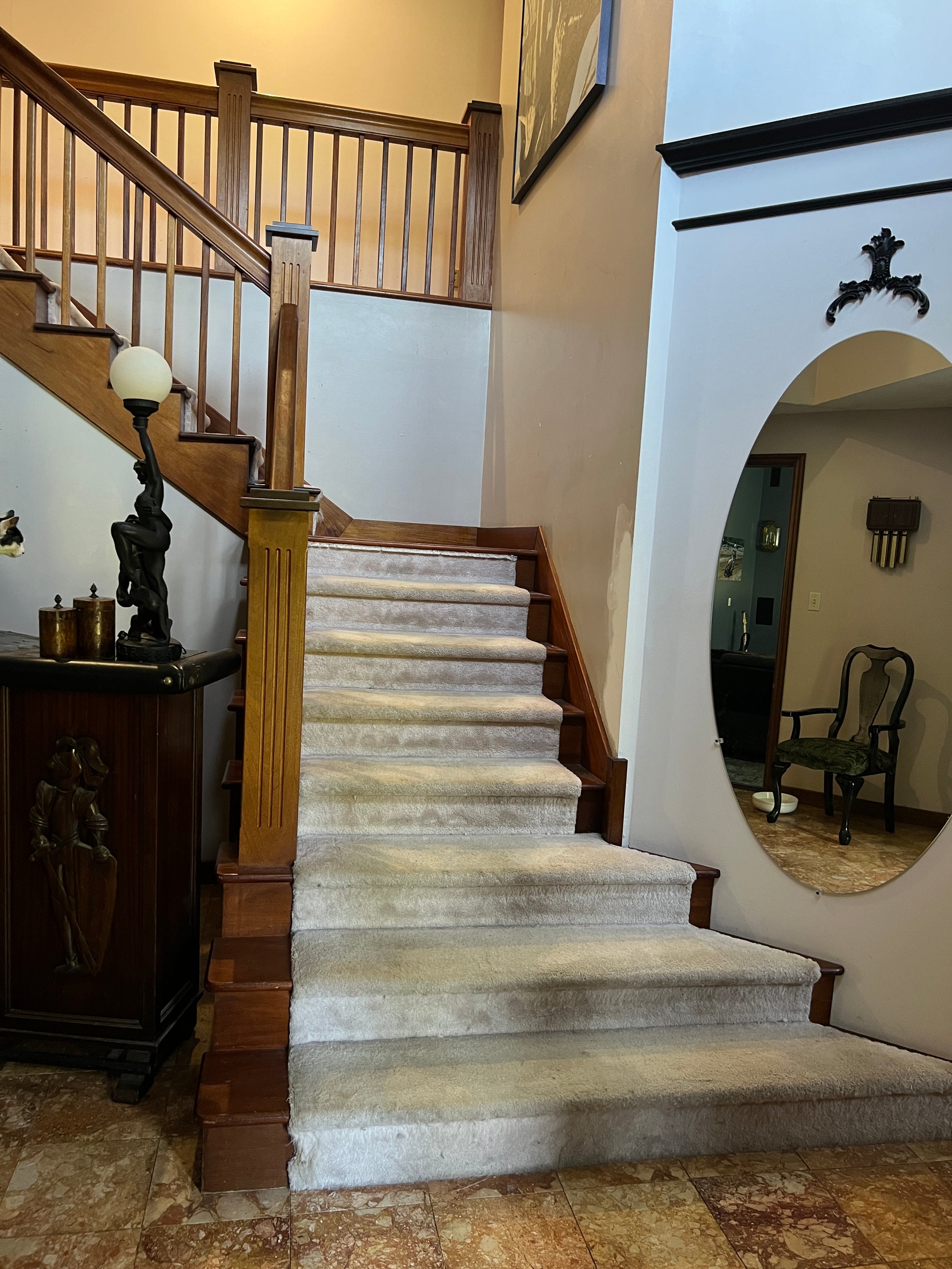 Wooden mahogany staircase with a white runner in a home interior setting.   Nature View NH Estate