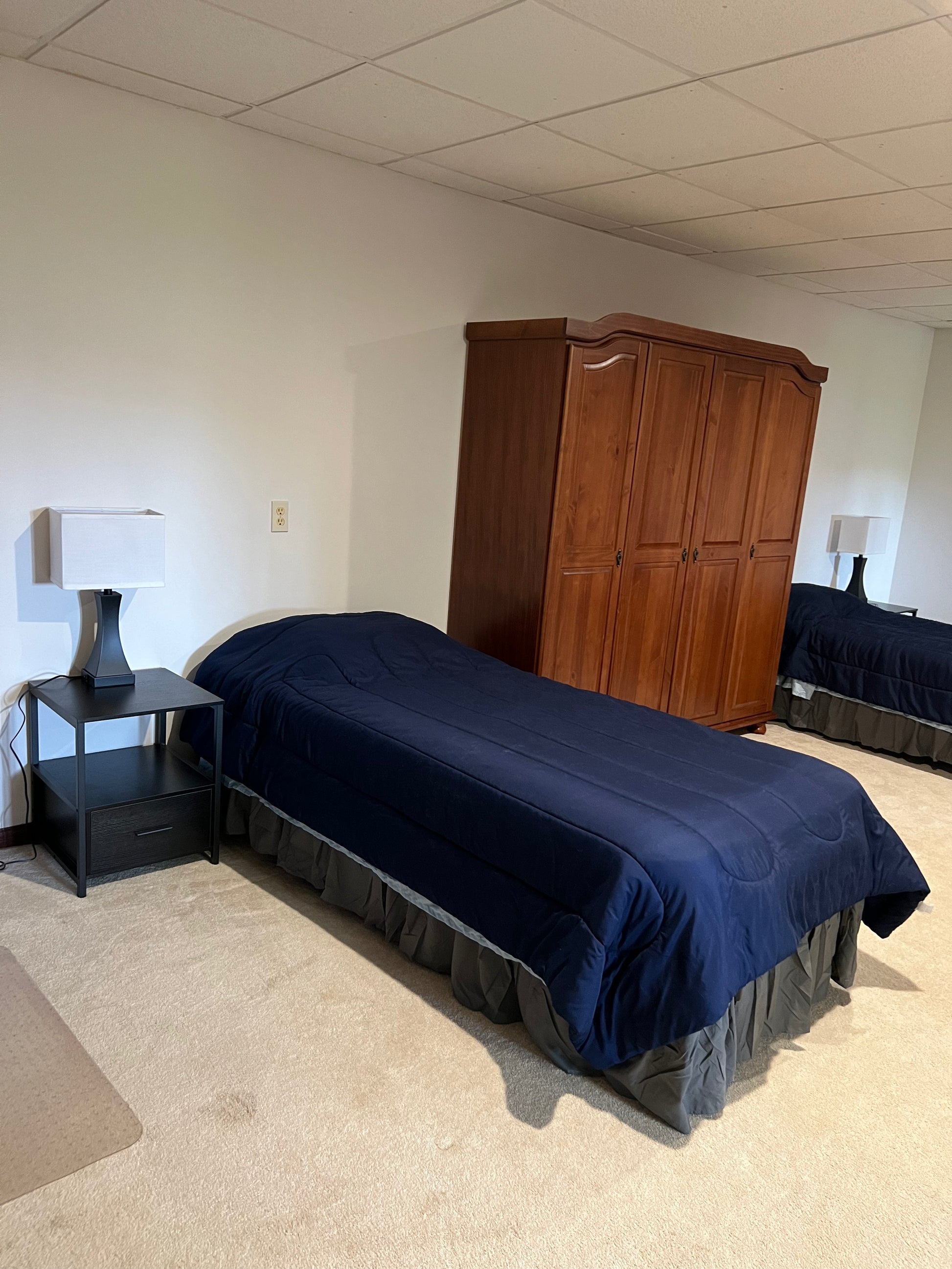 Bedroom with a bed, nightstand, and wardrobe.