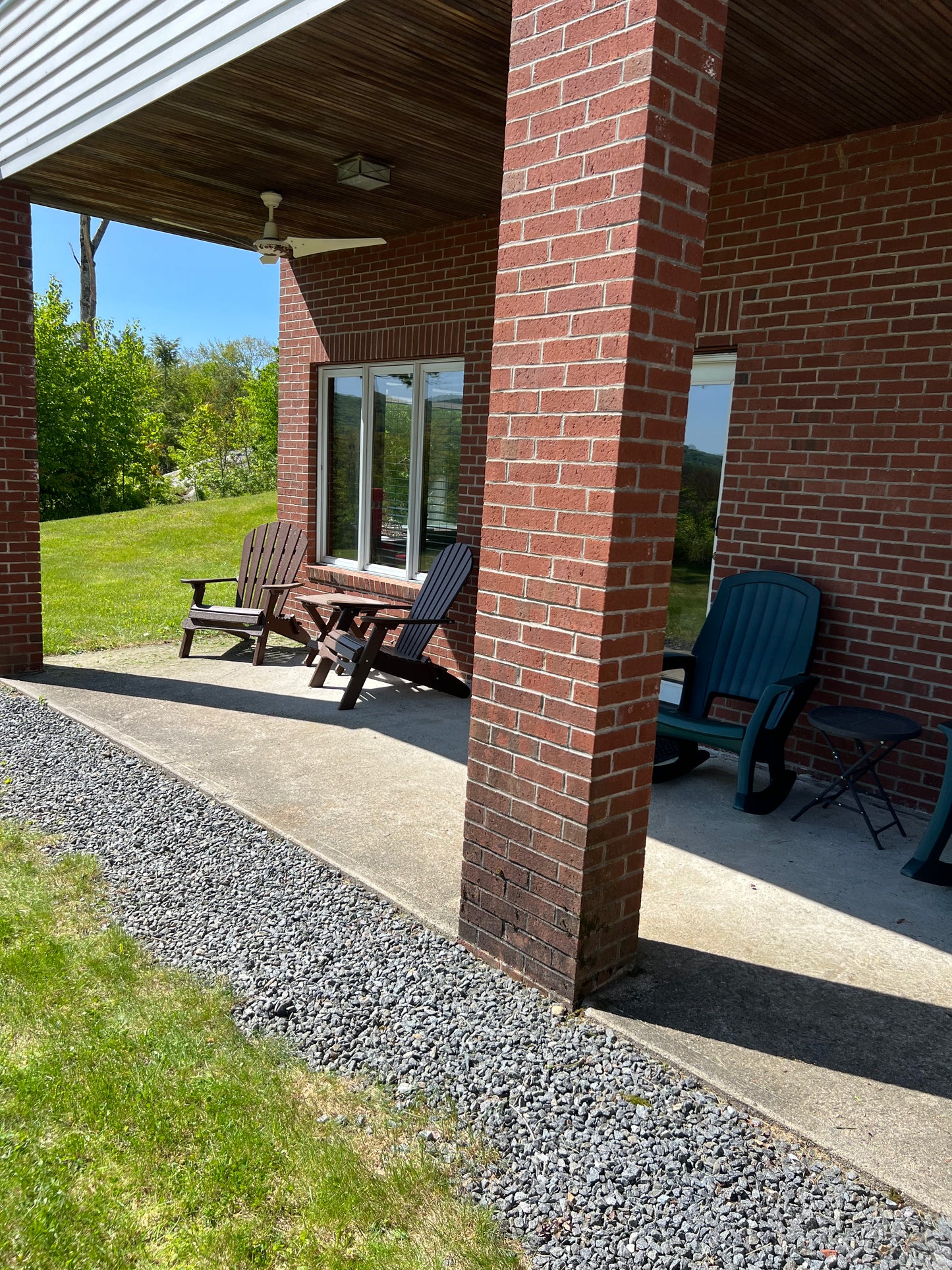 Outdoor patio area with chairs and a table on a sunny day.