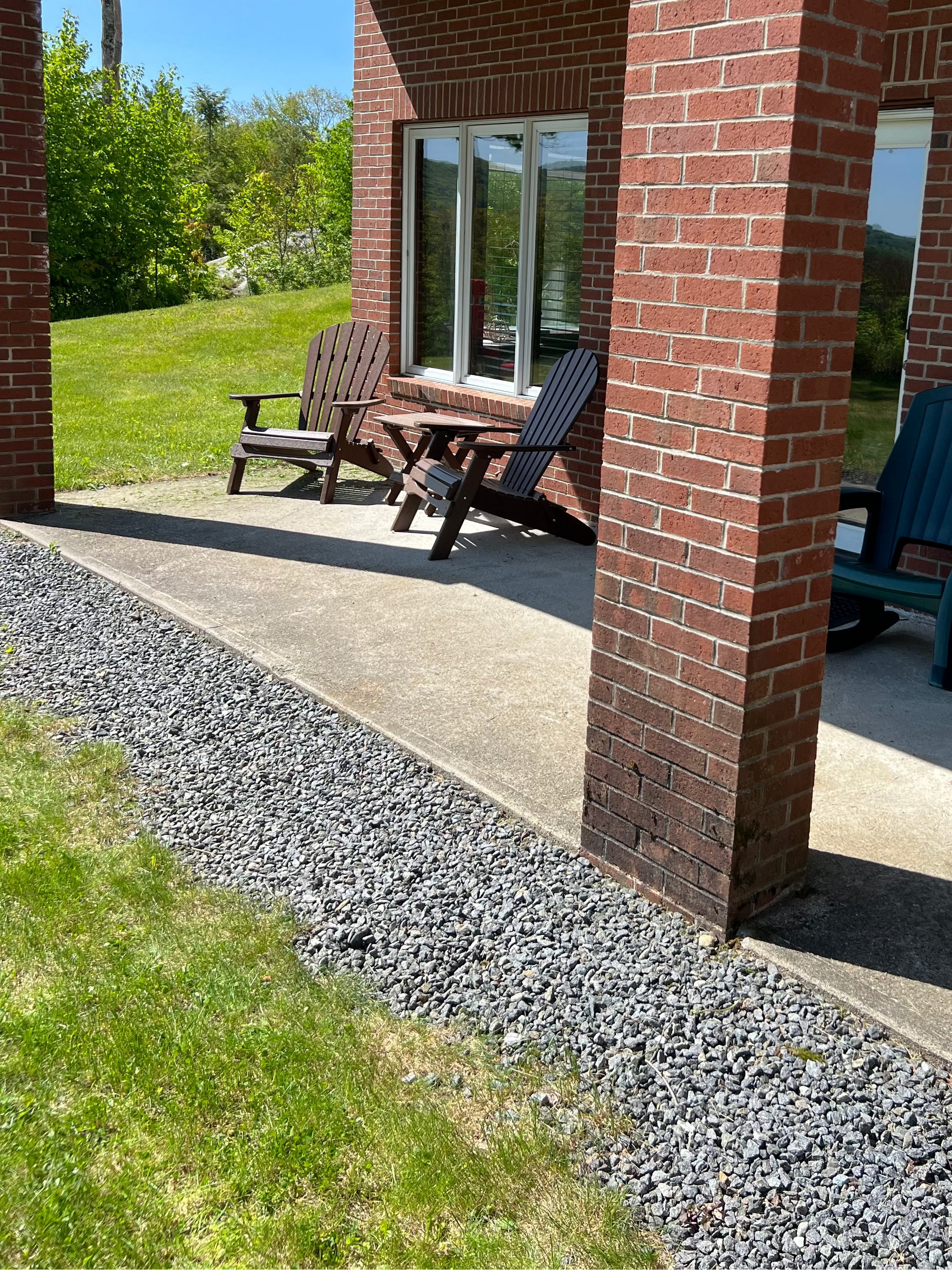 Outdoor patio area with chairs and a table on a sunny day.
