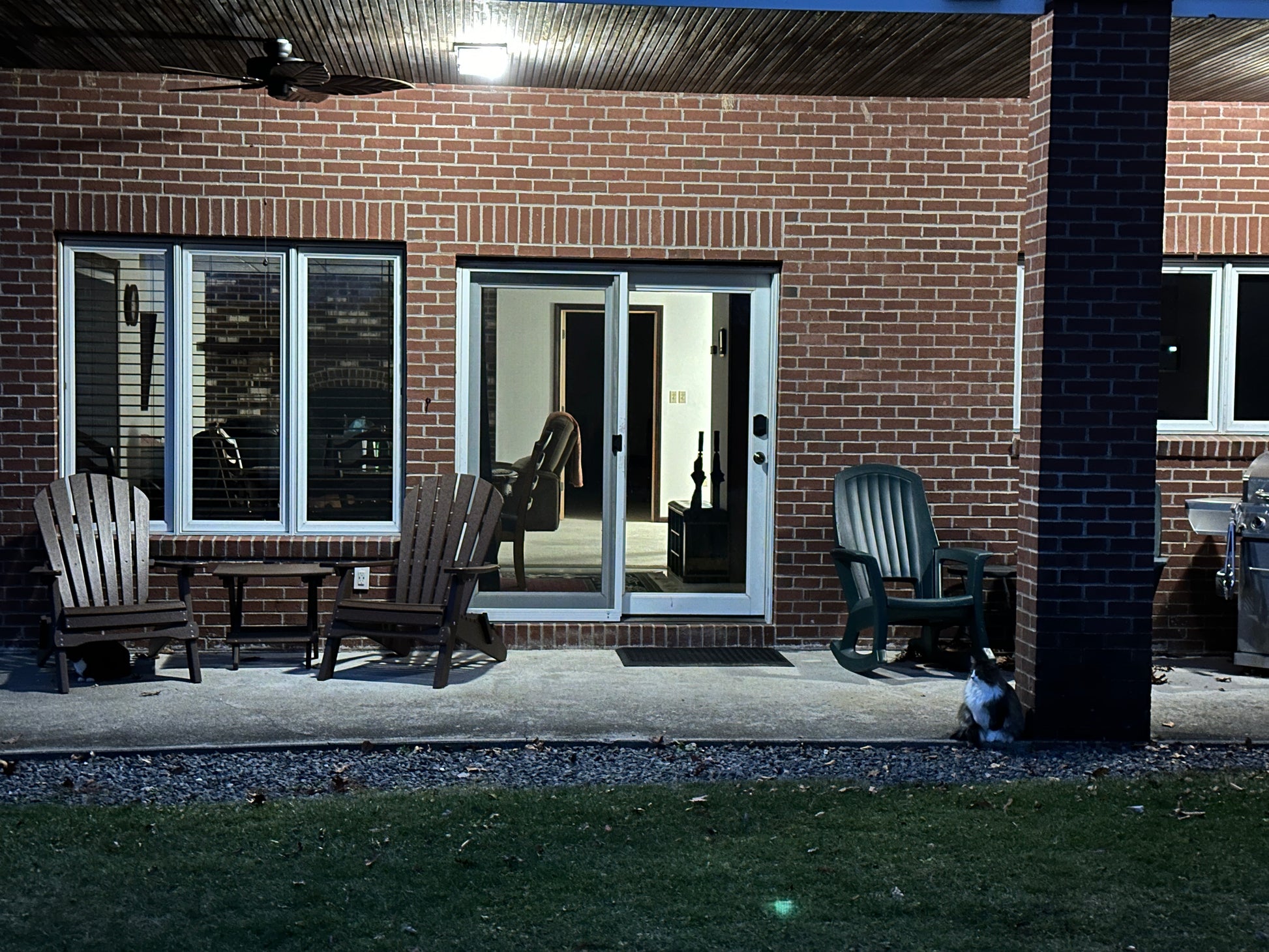 Outdoor patio area with chairs and a sliding glass door at night. Looking into the guest suite. Nature View NH Estate .
