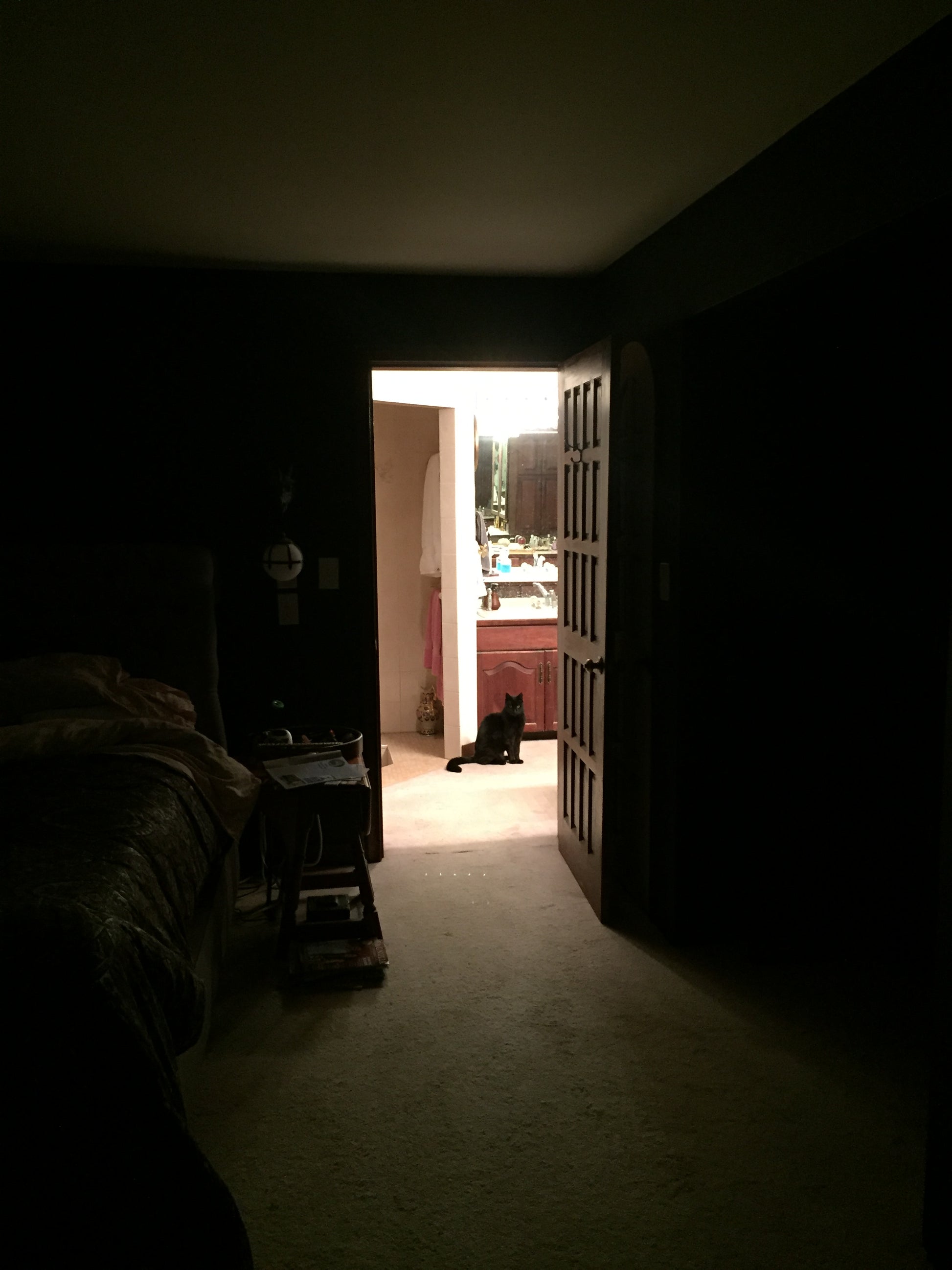Dark room with a light source on a wall, creating a silhouette effect.