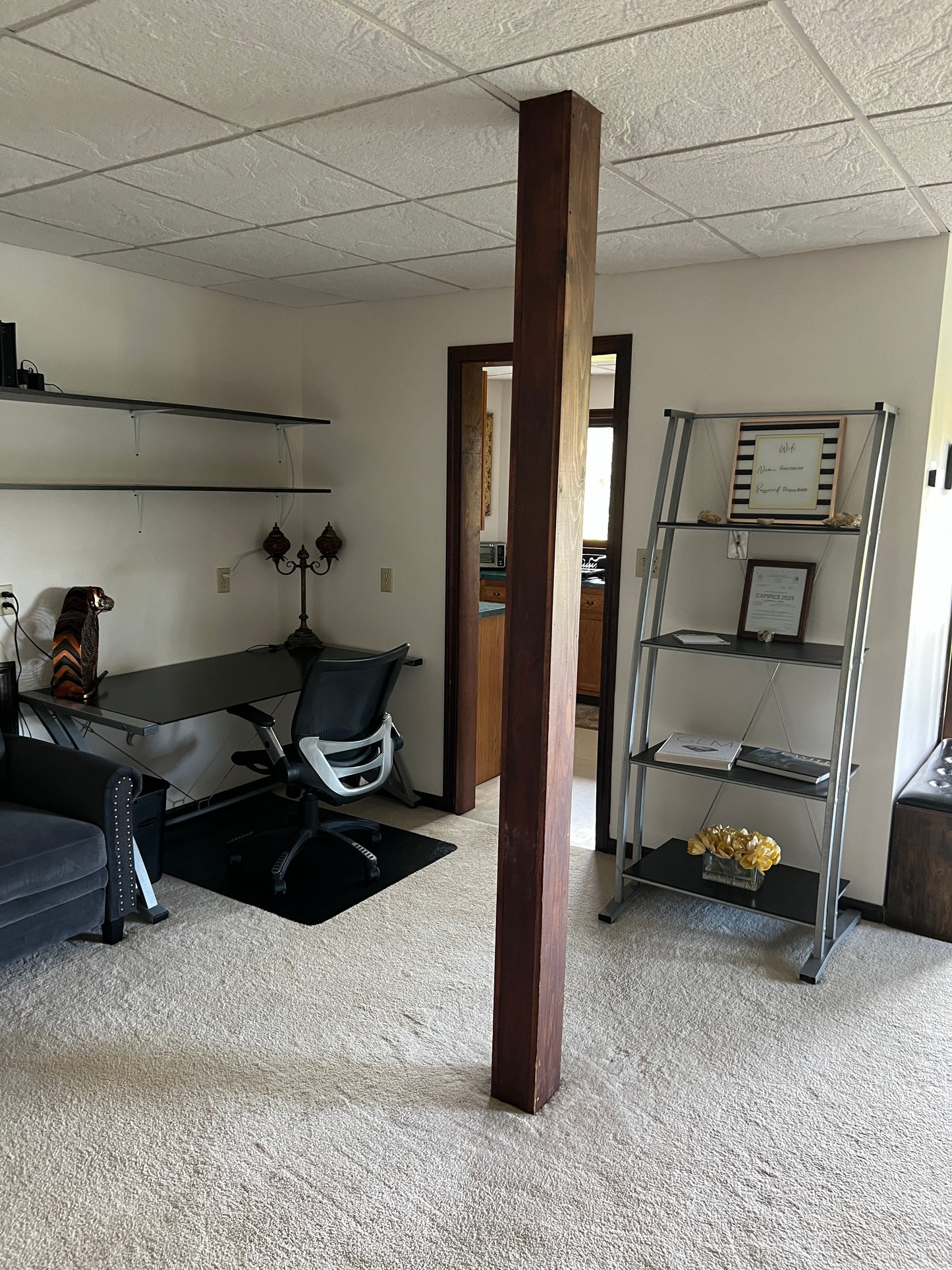 Modern interior design with a wooden shelf, mirror, and furniture.