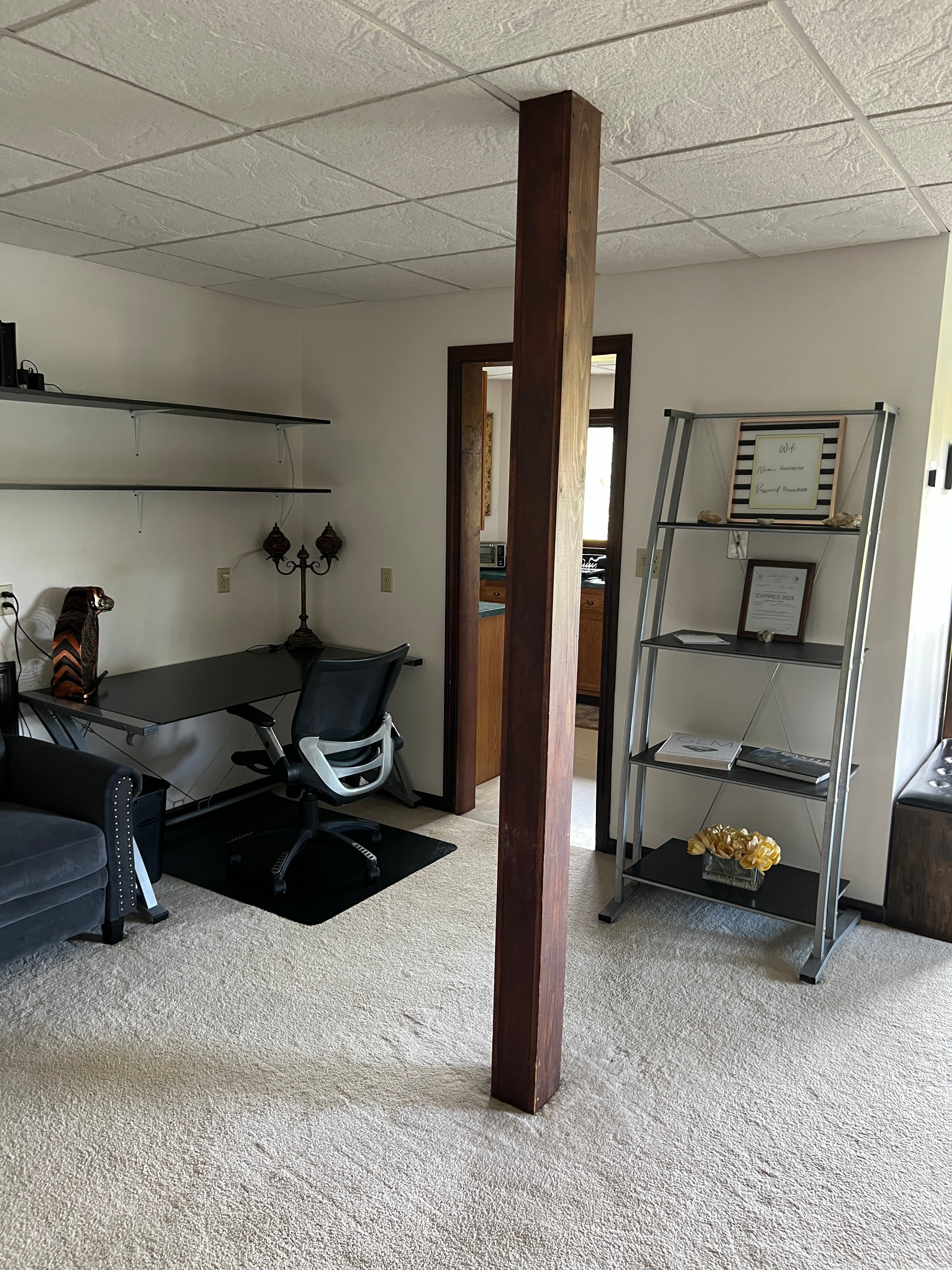 Modern interior design with a wooden shelf, mirror, and furniture.