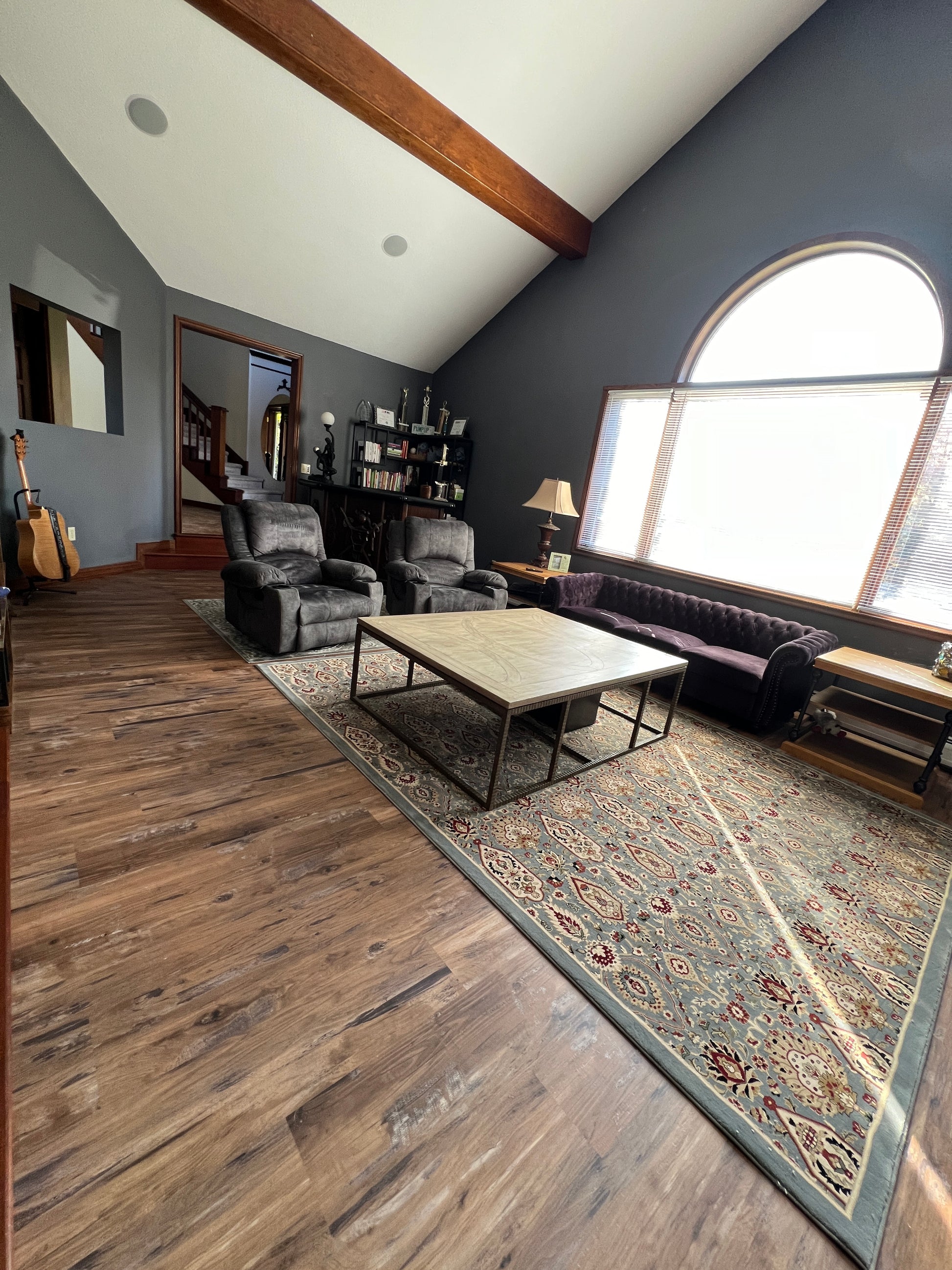 A modern interior with a staircase, rug, and furniture.