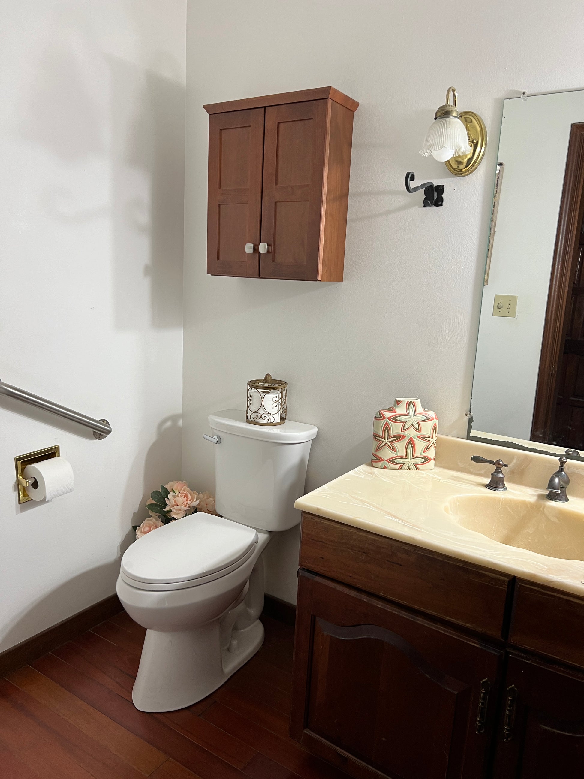 Bathroom with wooden vanity, toilet, and sink.