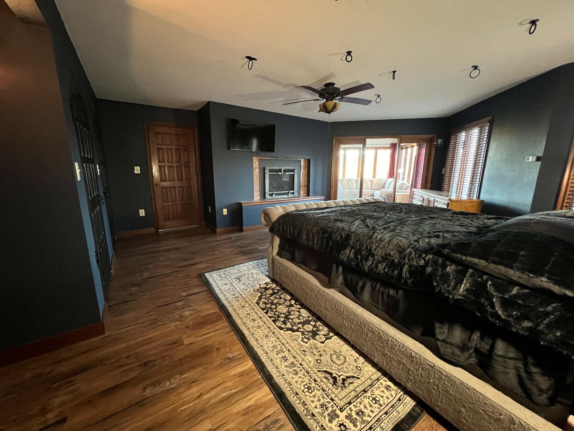 Master bedroom with large bed, multi closets, and fireplace.