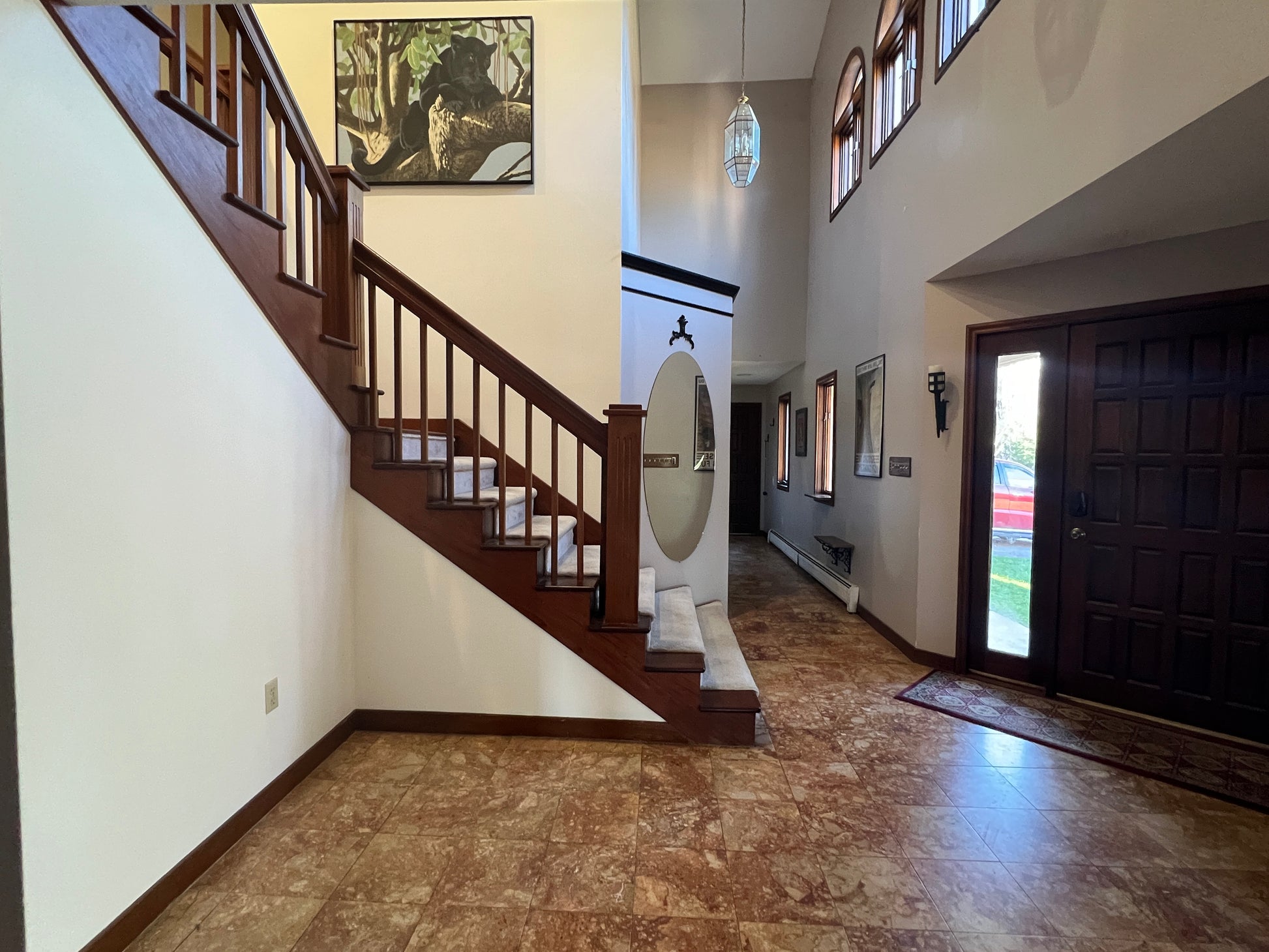 Staircase in a home with wooden railings and a large mirror on the wall.