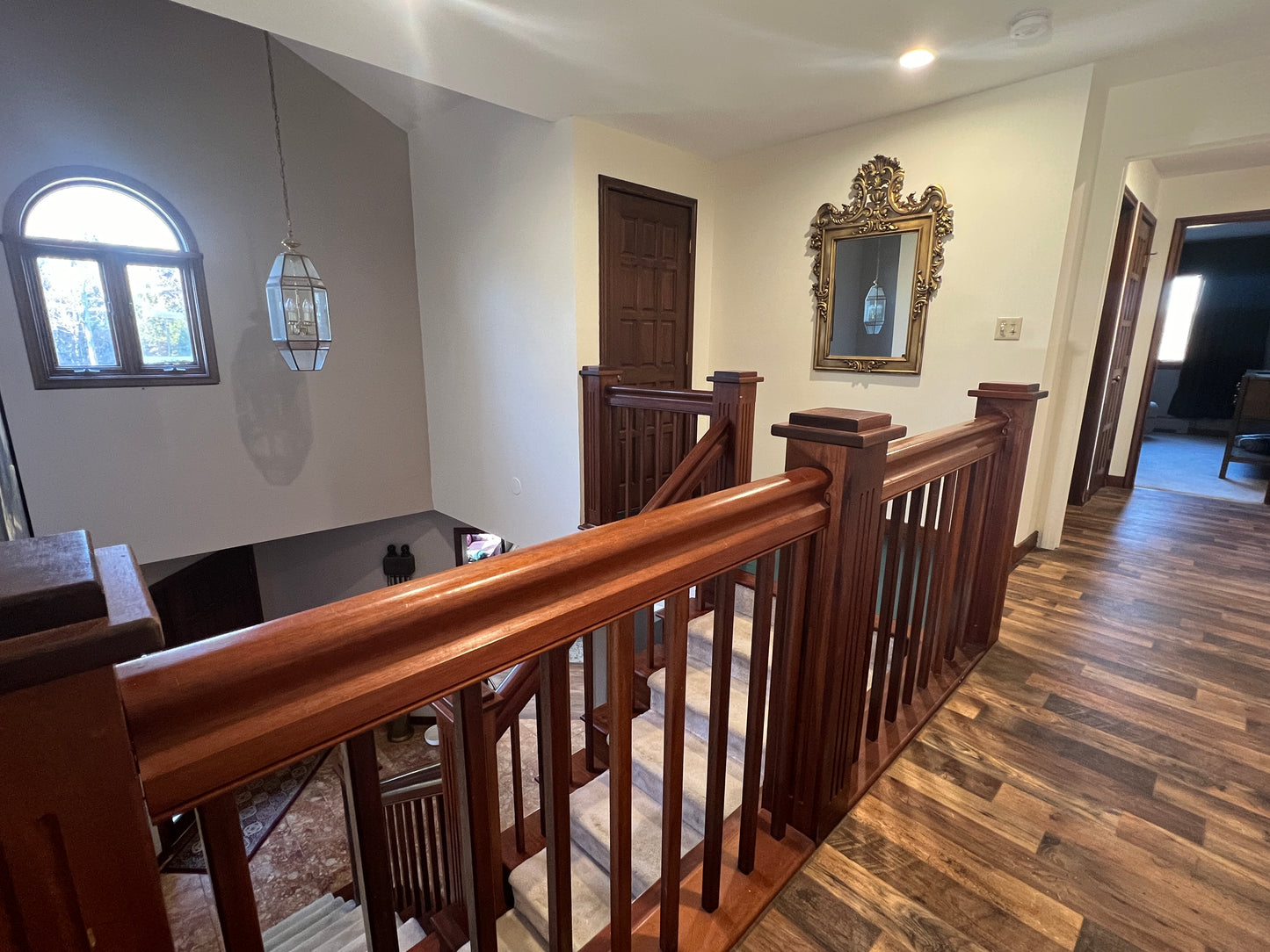 Staircase mahogany with wooden railings in a home interior Nature View NH Estate