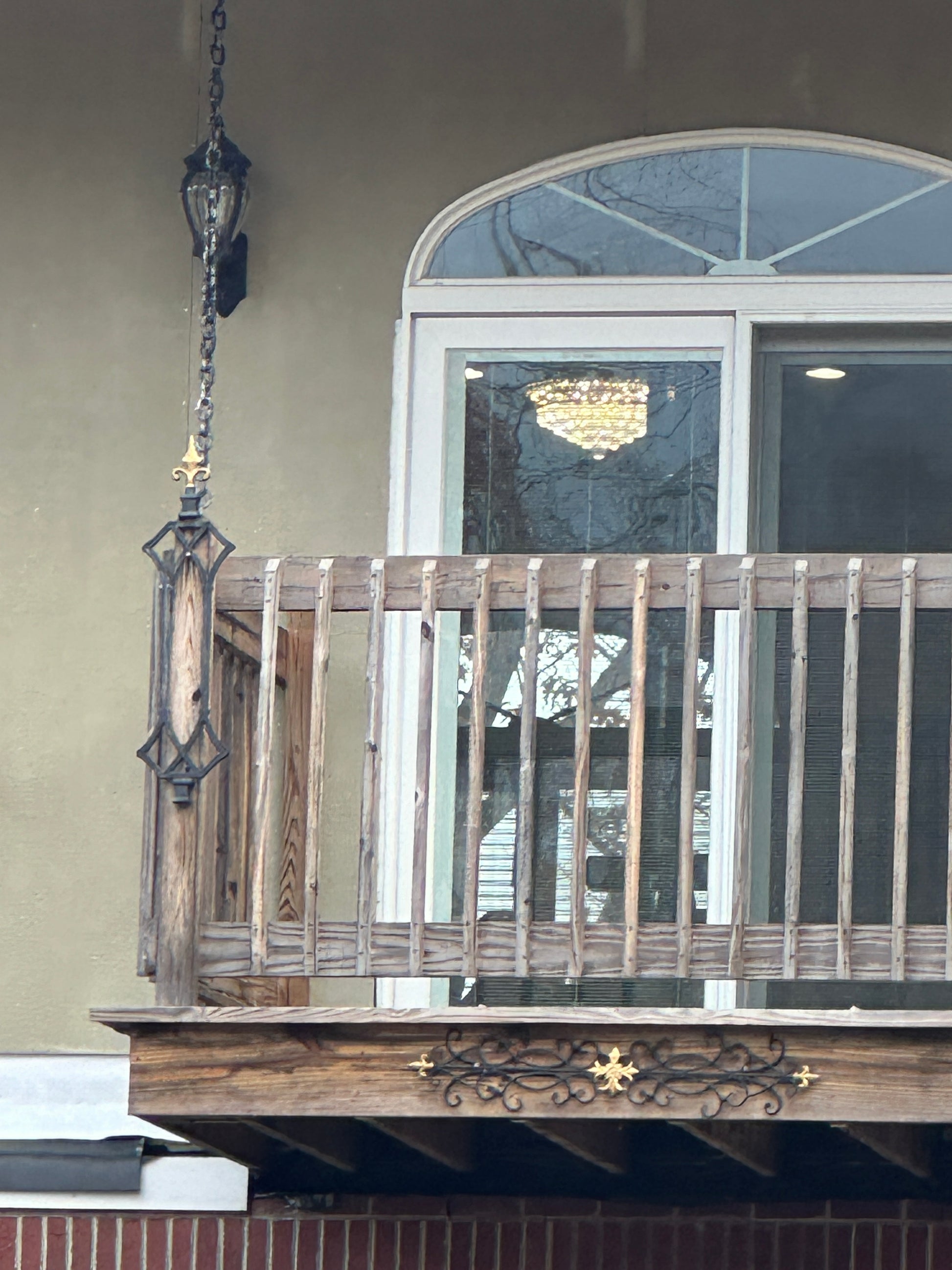 Decorative front door with glass panels and wooden deck and chains.