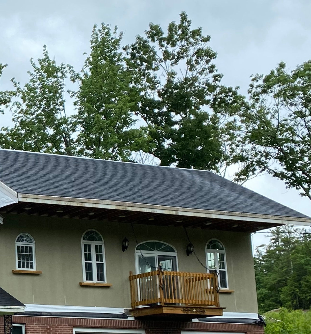 Brick house with a draw bridge style deck on a cloudy day.