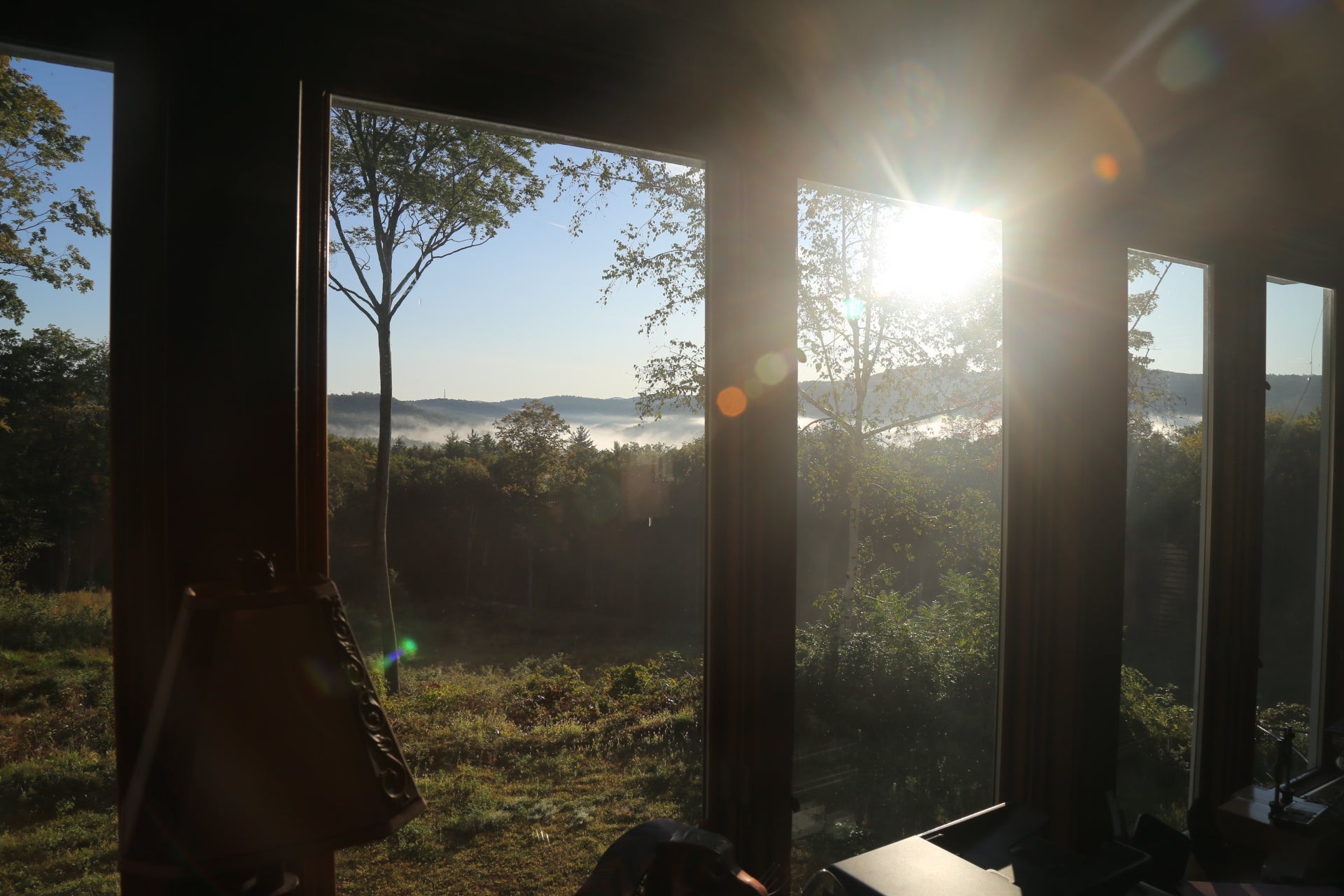 Sunlight streaming through large windows with a view of trees and landscape