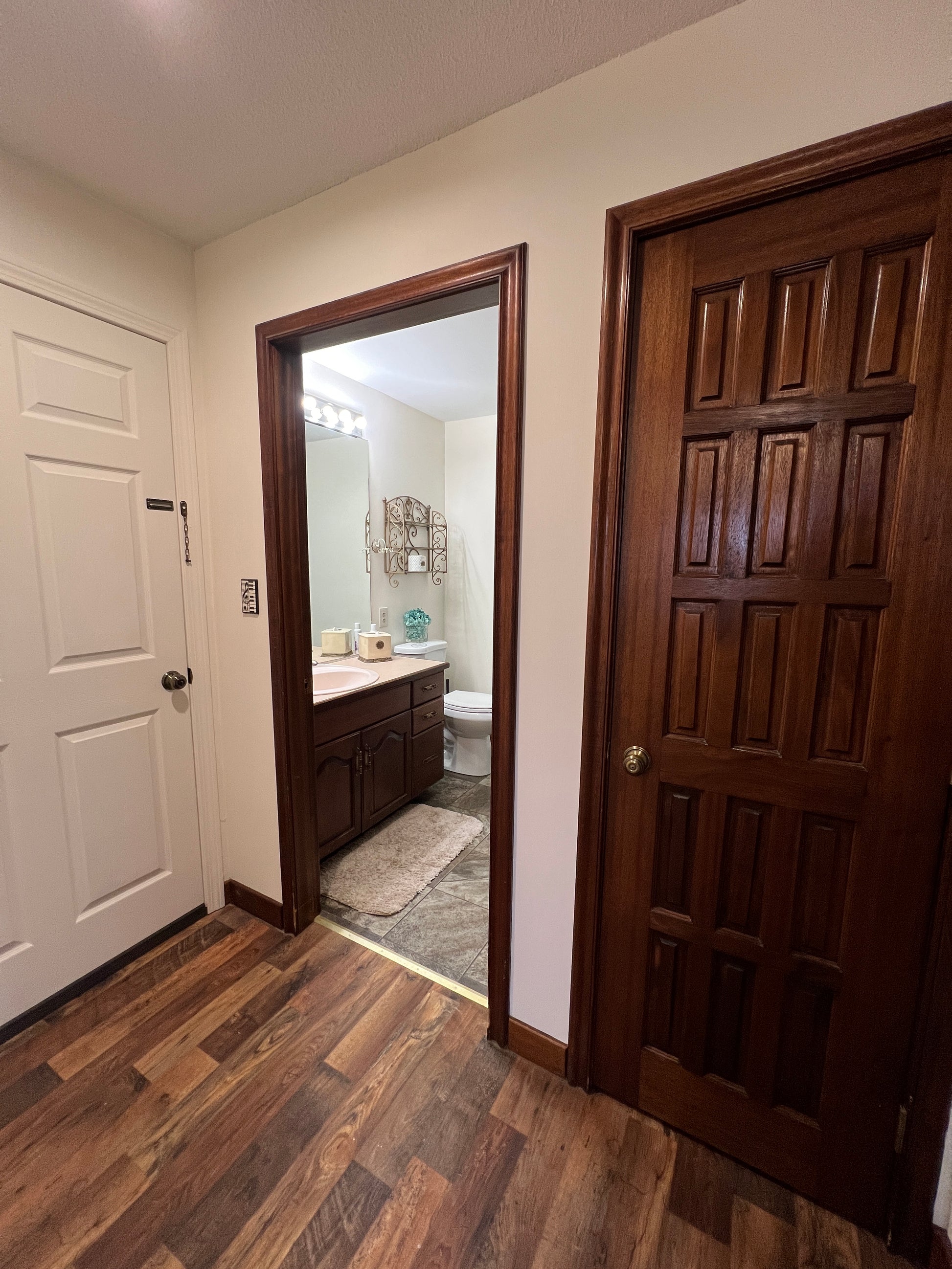 Wooden door with a small window and white door below, on a wooden floor.