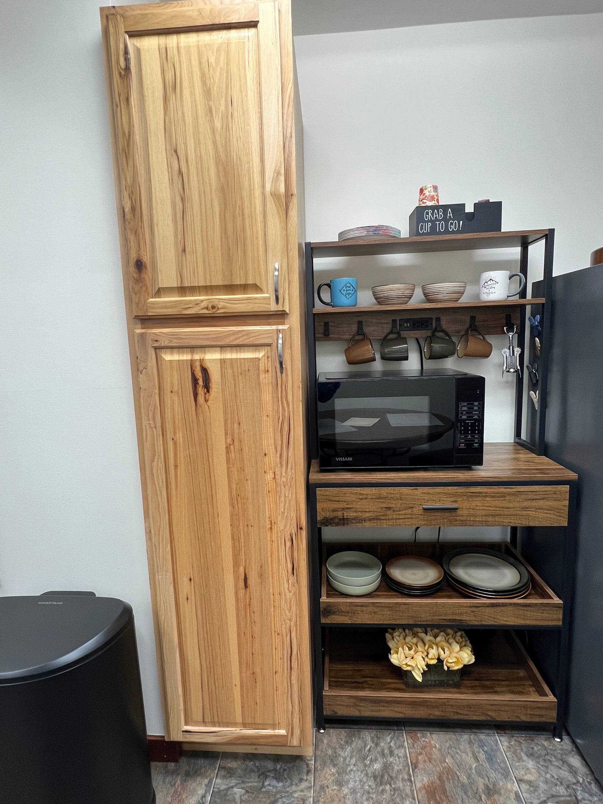 Wooden cabinet with open shelves displaying decorative items against a painted  wall.