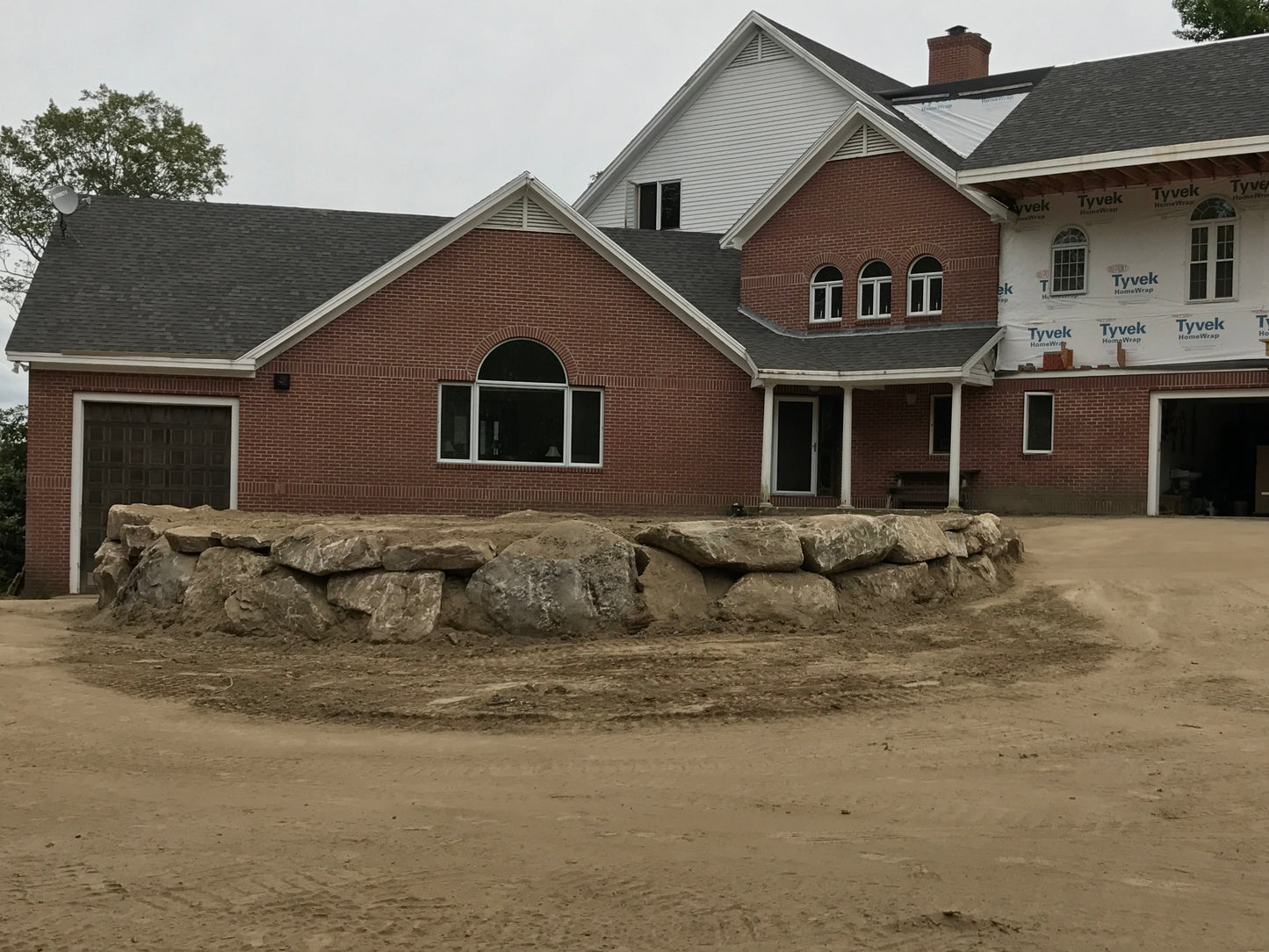 Brick building with stone feature in front on a cloudy day