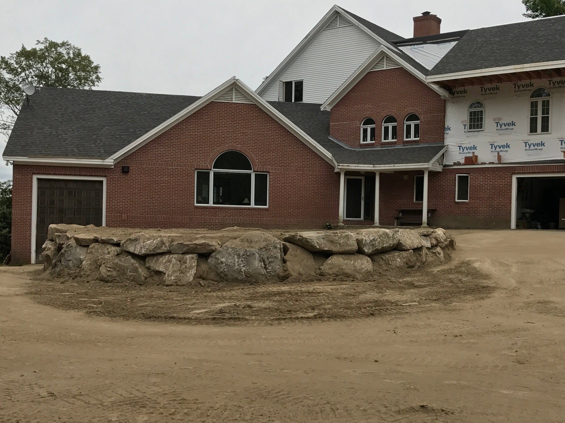 Brick building with stone feature in front on a cloudy day