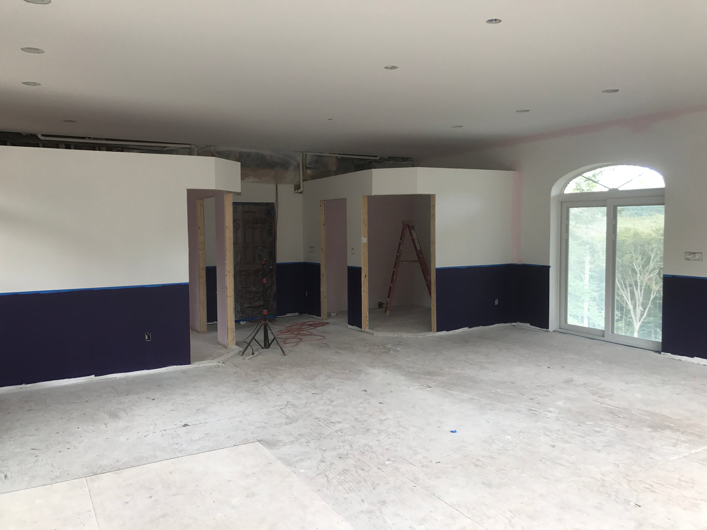 Large room under construction with white walls and a blue wanes  coating Nature View NH Estate