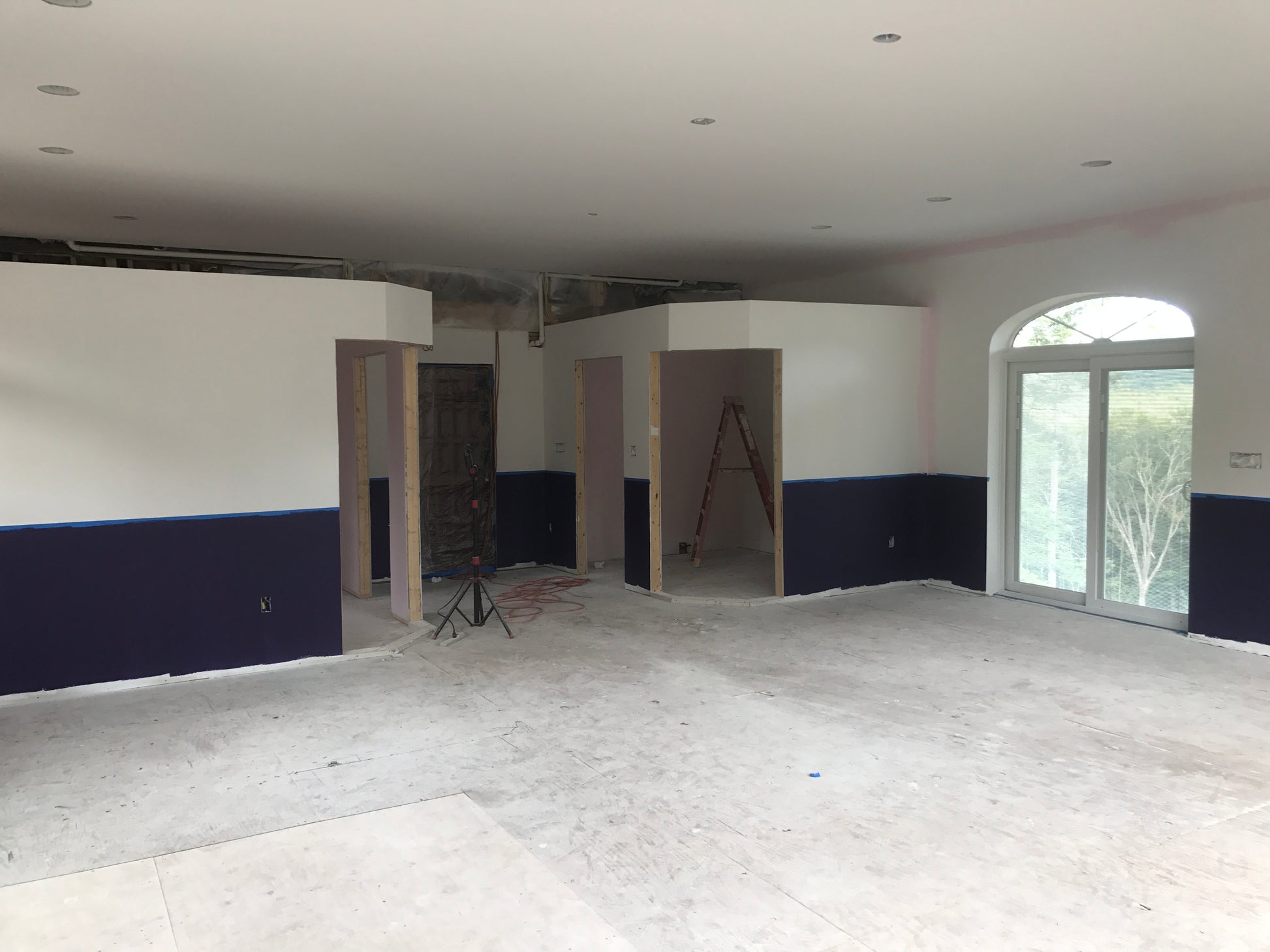 Large room under construction with white walls and a blue wanes  coating Nature View NH Estate