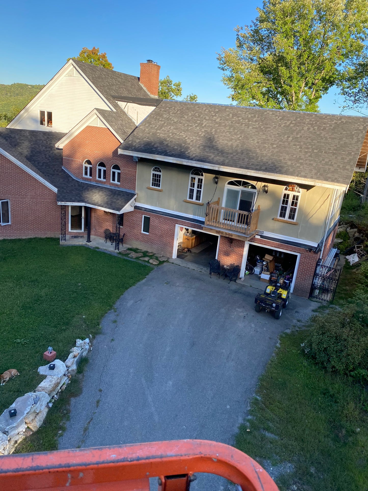 Aerial view of a house with a driveway and surrounding area.