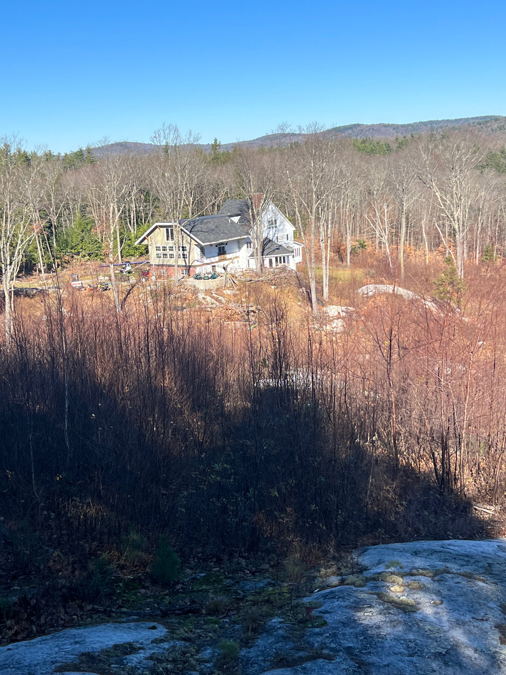 Top of the mountain on property. Looking at Nature View NH Estate surrounded by trees and mountains on a clear day