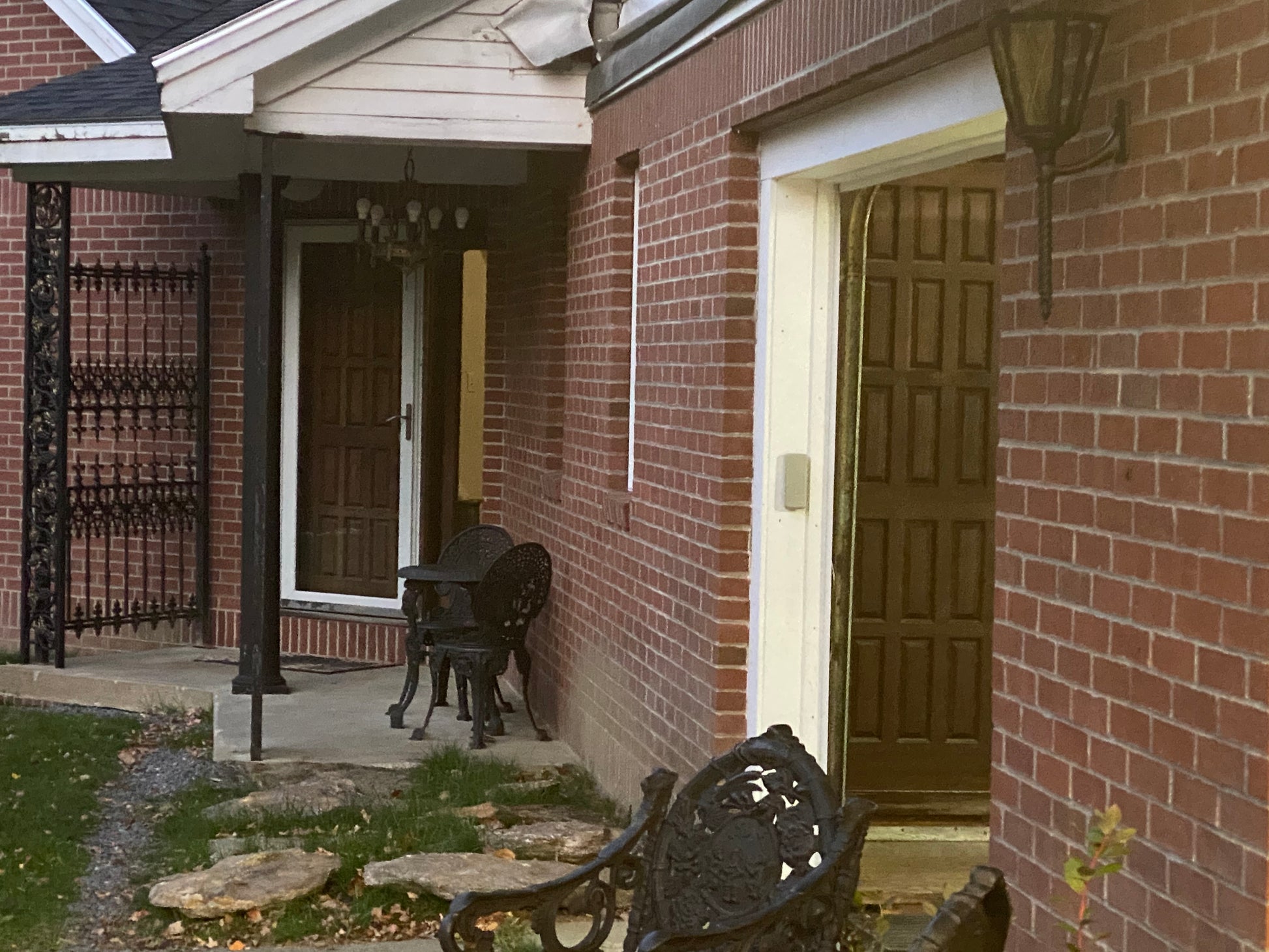 Brick house exterior with a patio area and outdoor furniture.