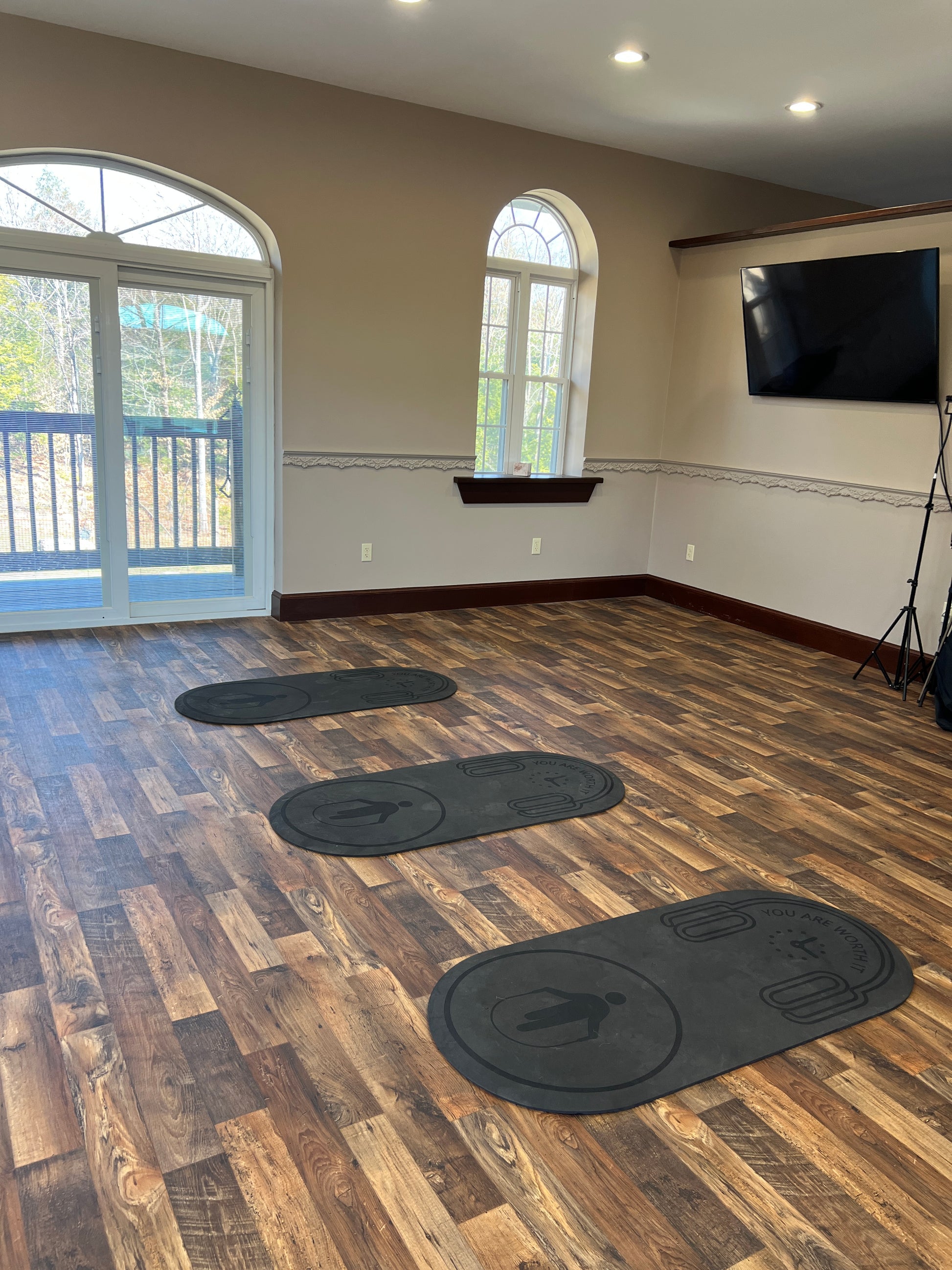 Fitness Room with large  arched windows, and black circular exercise  mats on the floor.